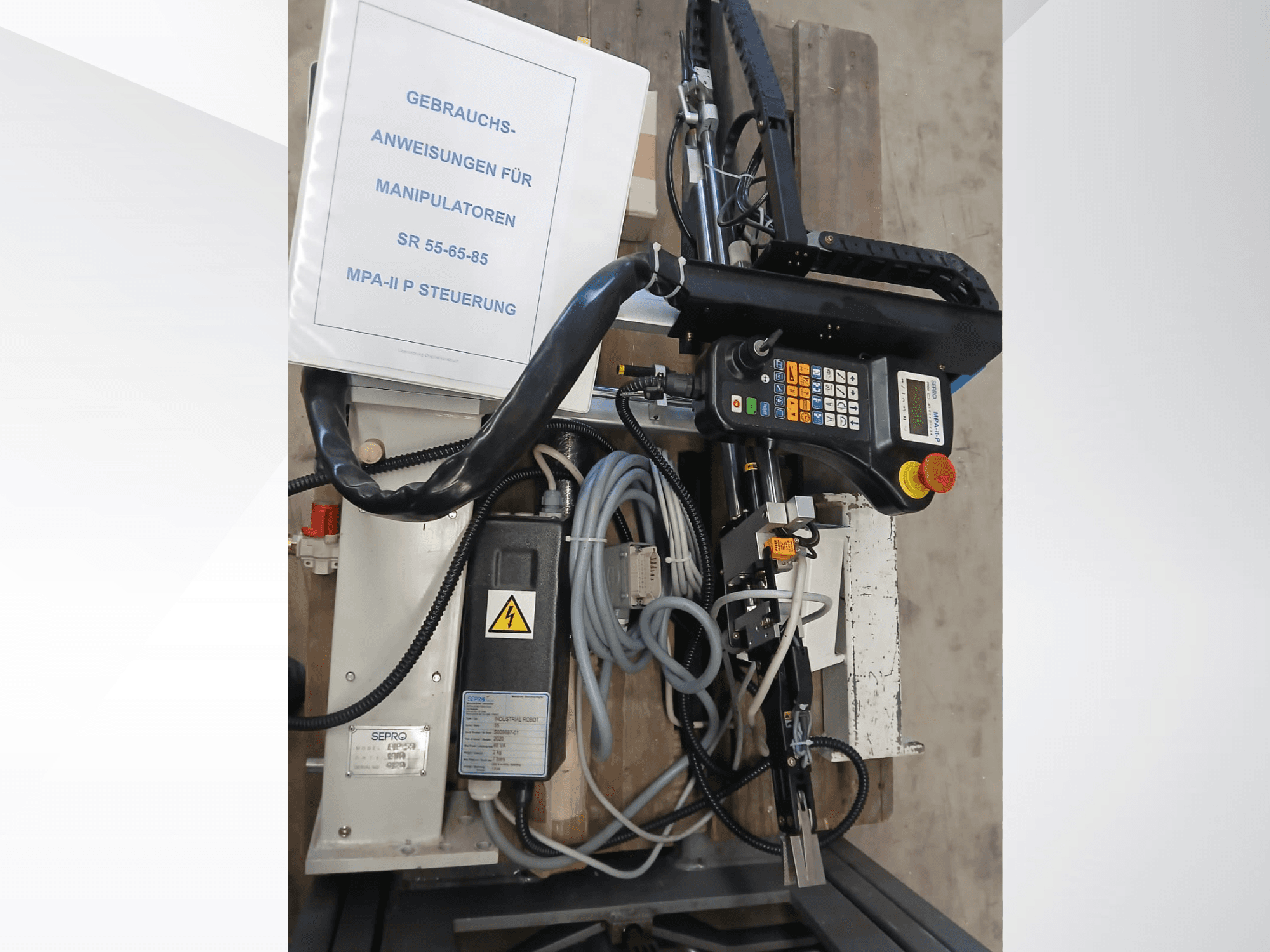 Sepro PIP-55 Gantry Roboti juhtpaneel ja komponendid, küljelt vaadatuna, kasutusjuhend nähtav.