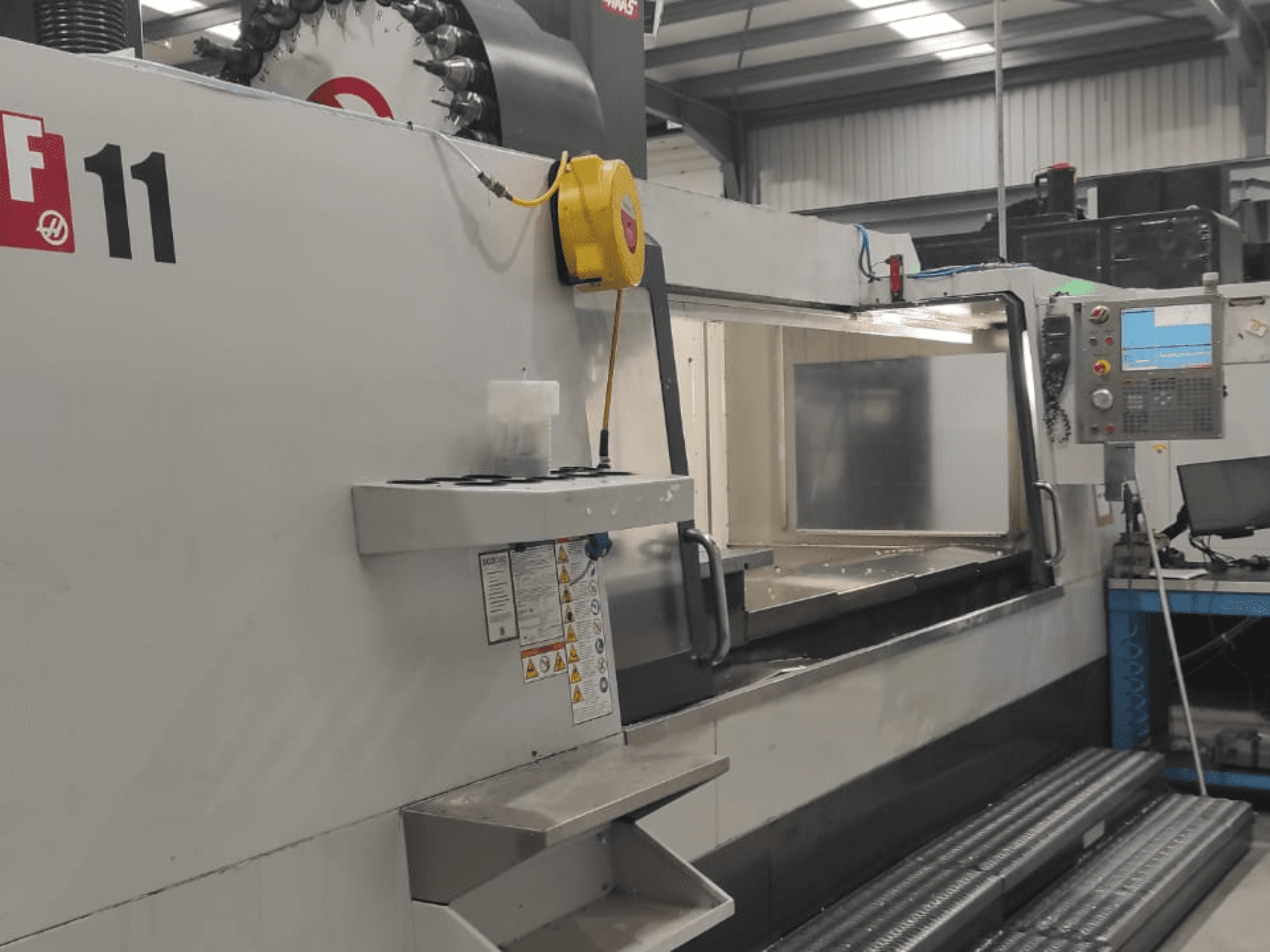 Haasi masin, mudel VF-11, näidatud esiplaanilt, kus on näha juhtpaneel, suur tööpind ja ohutussildid.