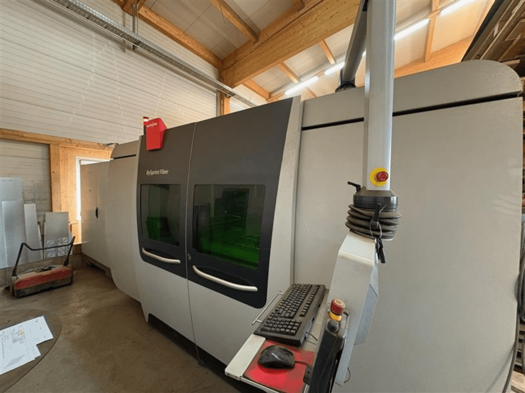 Bystronic ByJet kiudude lõikamismasin töökojas, esiplaanil on juhtpaneel ja kaks rohelist vaateakent.