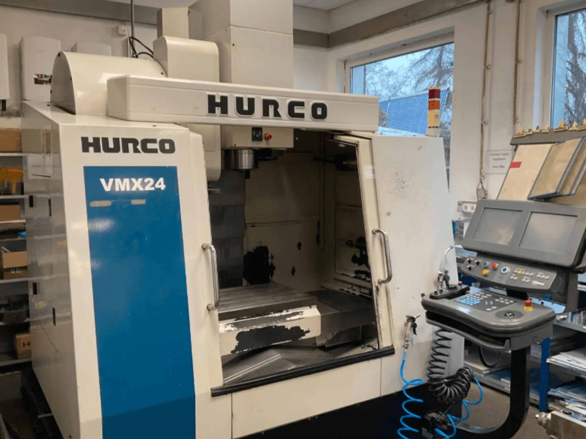 Hurco VMX24 vertikaalne töötlemiskeskus vaates eest, millel on näha juhtpaneel, spindlipea ja töötsoon ning mõned kulumisjäljed.