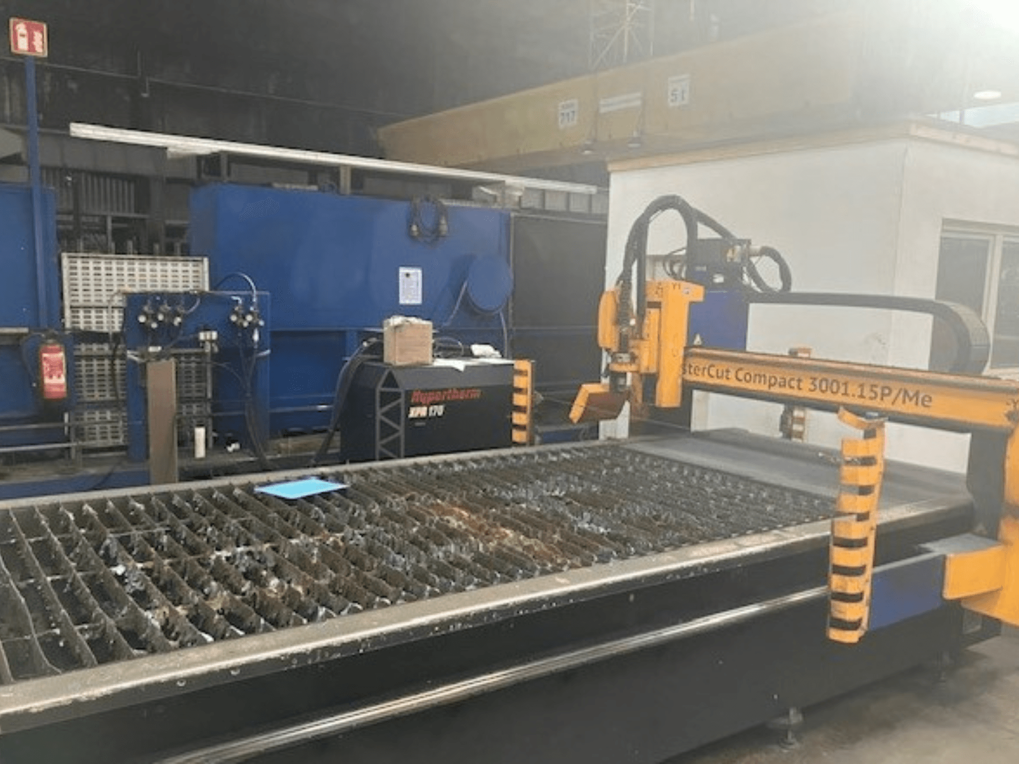 Hypertherm MasterCut Compact 3001.15P/Me plasmalõikepink külgvaates, millel on näha lõikelaua ja juhtpaneel.