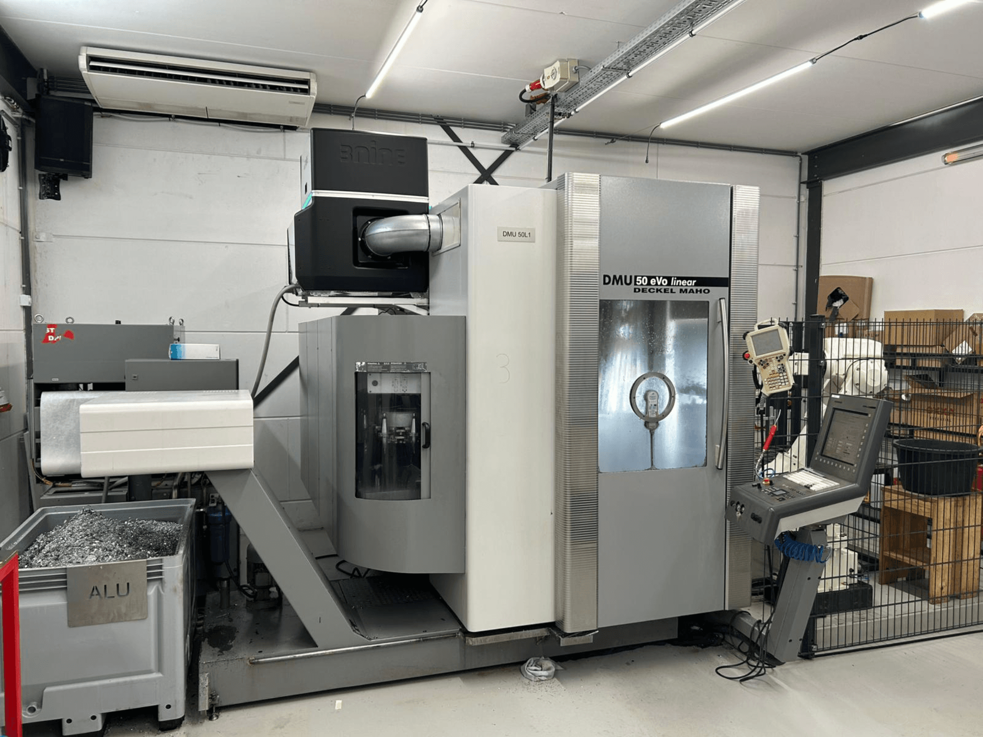 DMU 50 eVo lineaarfreesimispink Deckel Maho, esiplaanil, juhtpaneel ja laastukonteiner.