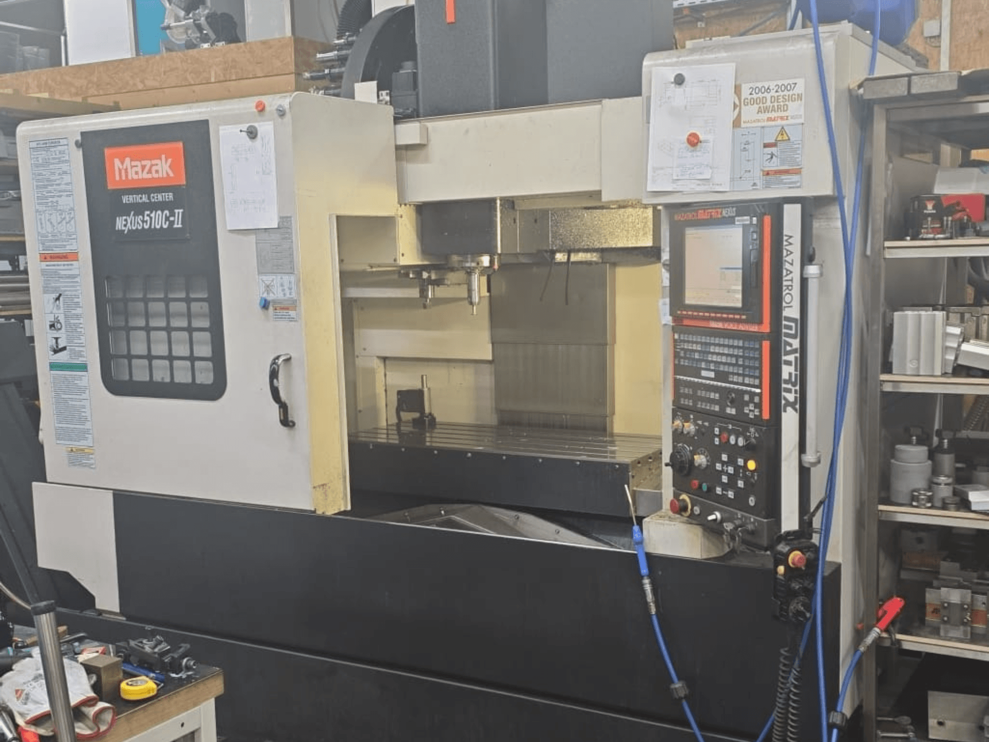 Mazak VERTICAL CENTER NEXUS 510C-II, esiplaanil on näidatud juhtpaneel, tööpiirkond ja tööfunktsioonid.