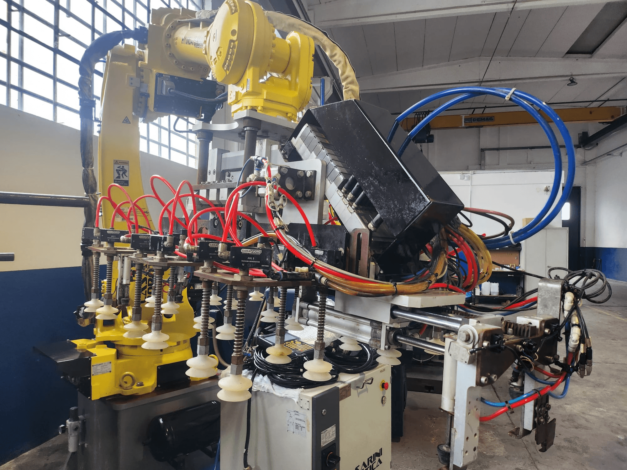 Hyundai Hi 5a-S robotkäsi esiplaanil, millel on mitu voolikut, juhtimiskomponendid ja keerukas kaablite paigutus.