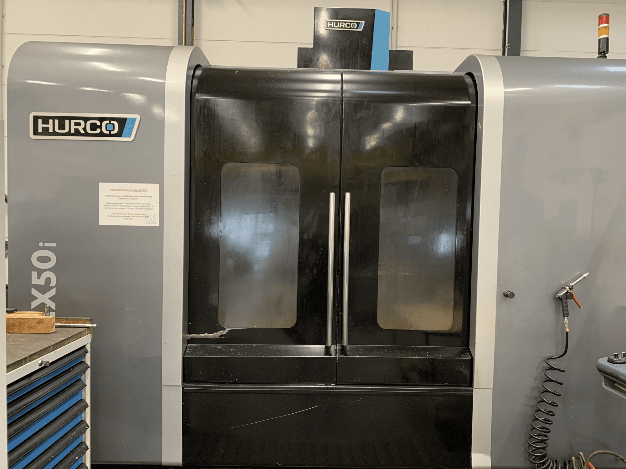 Hurco VX50i CNC-pingi esivaade kahe uksega, millel on näha tehnilised juhtimisseadmed ja küljel hooldussilt.