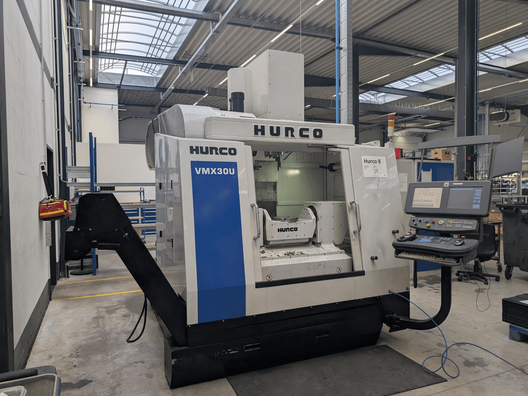 Hurco VMX30U CNC-tööpink töökojas, esivaade, millel on juhtpaneel koos nuppude ja andmenäidikuga.