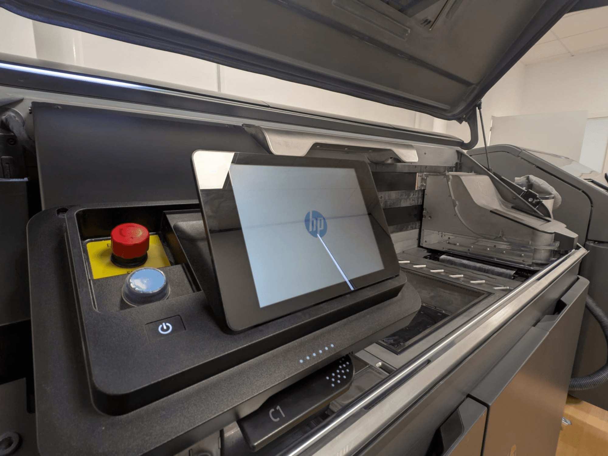 HP printeri juhtpaneel, millel on näha tahvelarvuti ekraan, punased ja sinised nupud ning printeri sisekomponentide külgvaade.