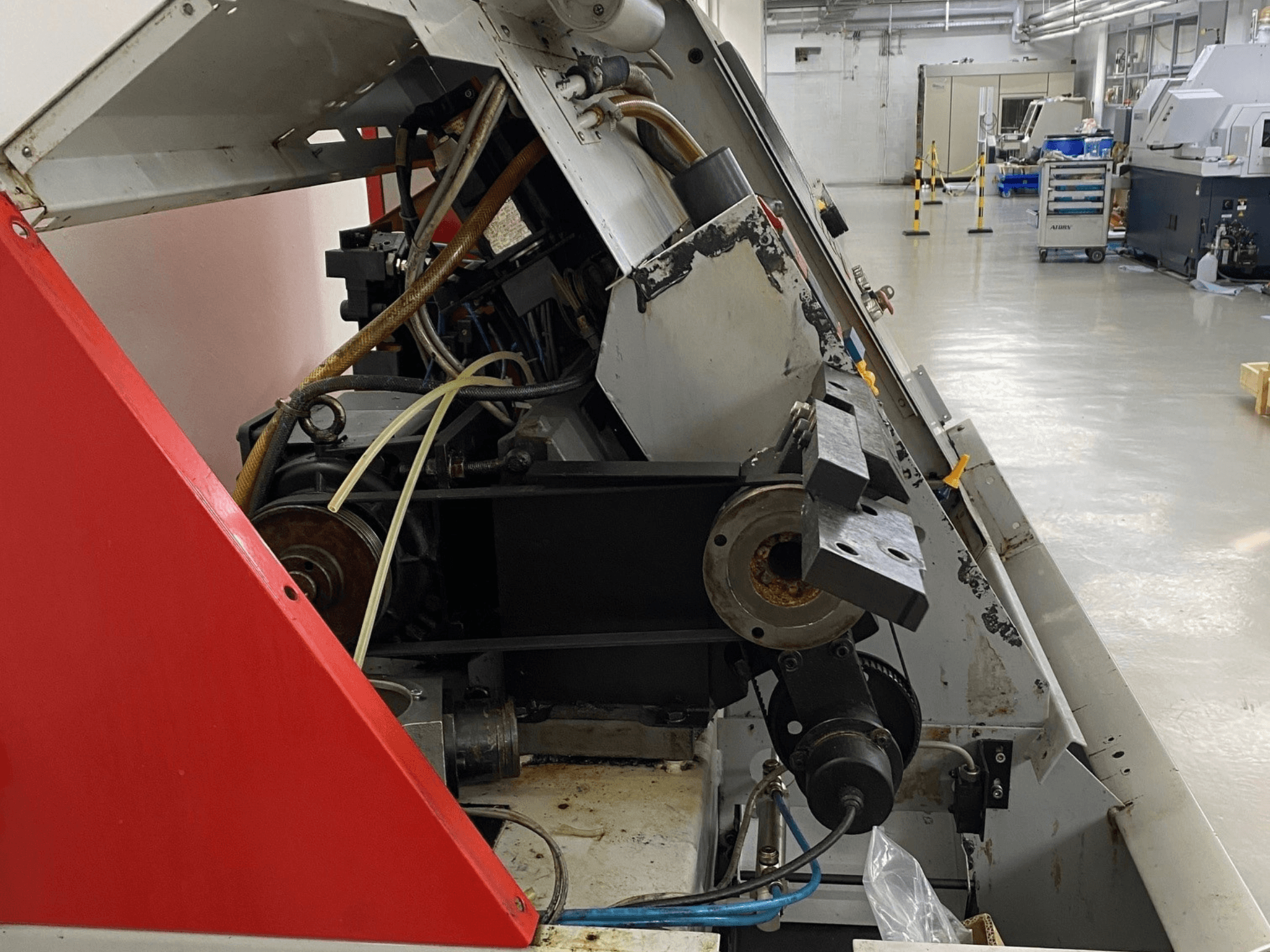 EMCO Emcoturn 325 horisontaalne treipingi, külgvaade, millel on kujutatud ajami komponendid ja hüdraulika tööstuslikus keskkonnas.