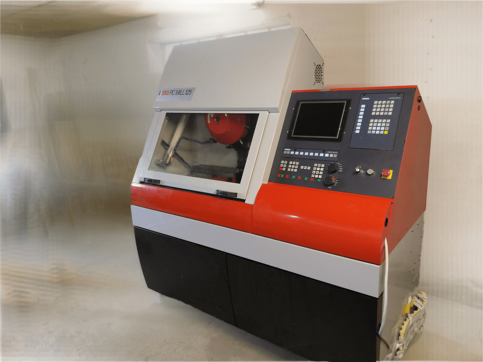 EMCO PC MILL 125 vertikaalne töötluskeskus, esiplaan, juhtpaneel ja nähtav töötlusala.