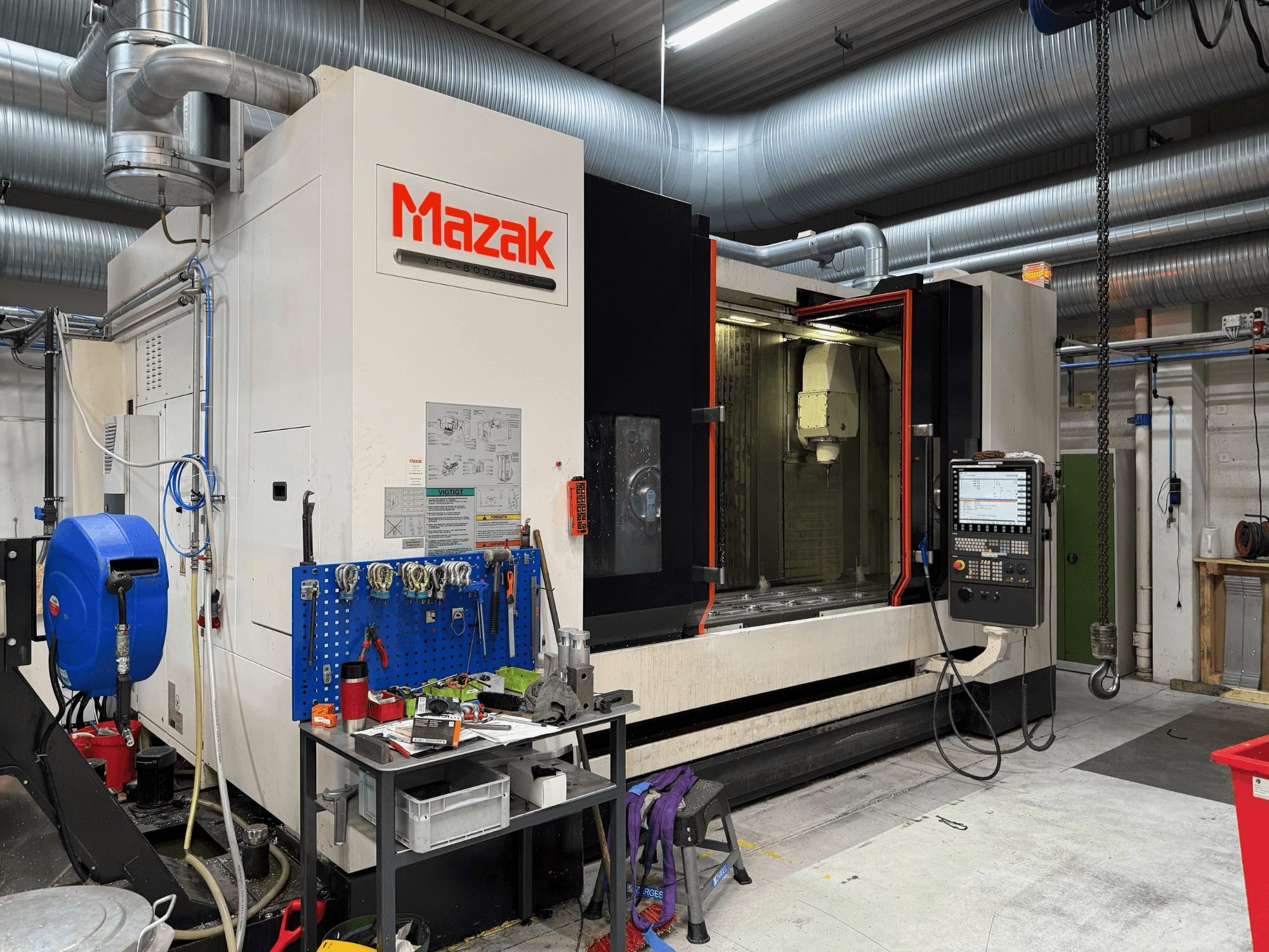 Mazaki CNC-tööpink eesvaates, kus on näha juhtimisseadmed, tööriistad ja tööruum töötluskeskkonnas.