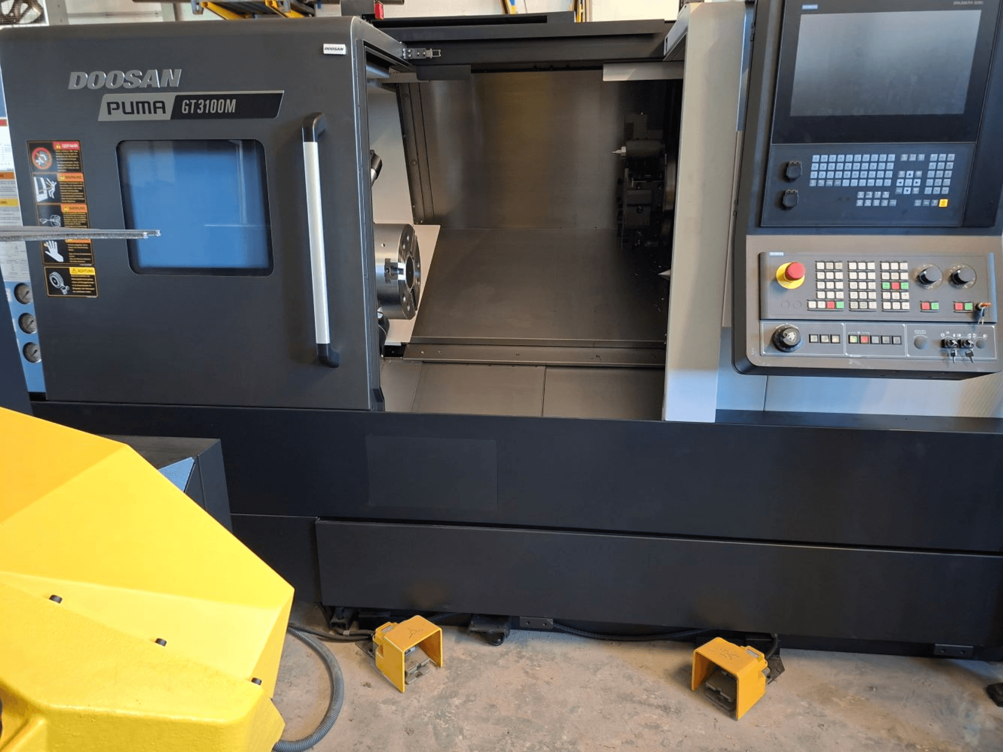 DOOSAN Puma GT 3100 M horisontaalne treipink eesvaates, kus on näha juhtpaneel, avatud revolver ja sisemine tööruum.