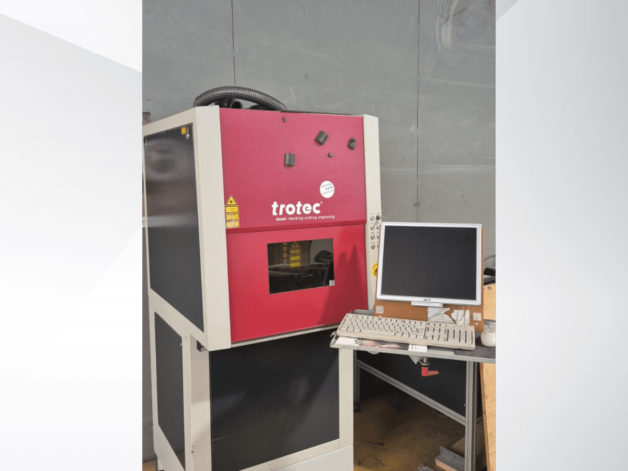 Punane Trotec Laser-Work-Station vaadatuna eestpoolt, millel on tööjaamal monitor ja klaviatuur.