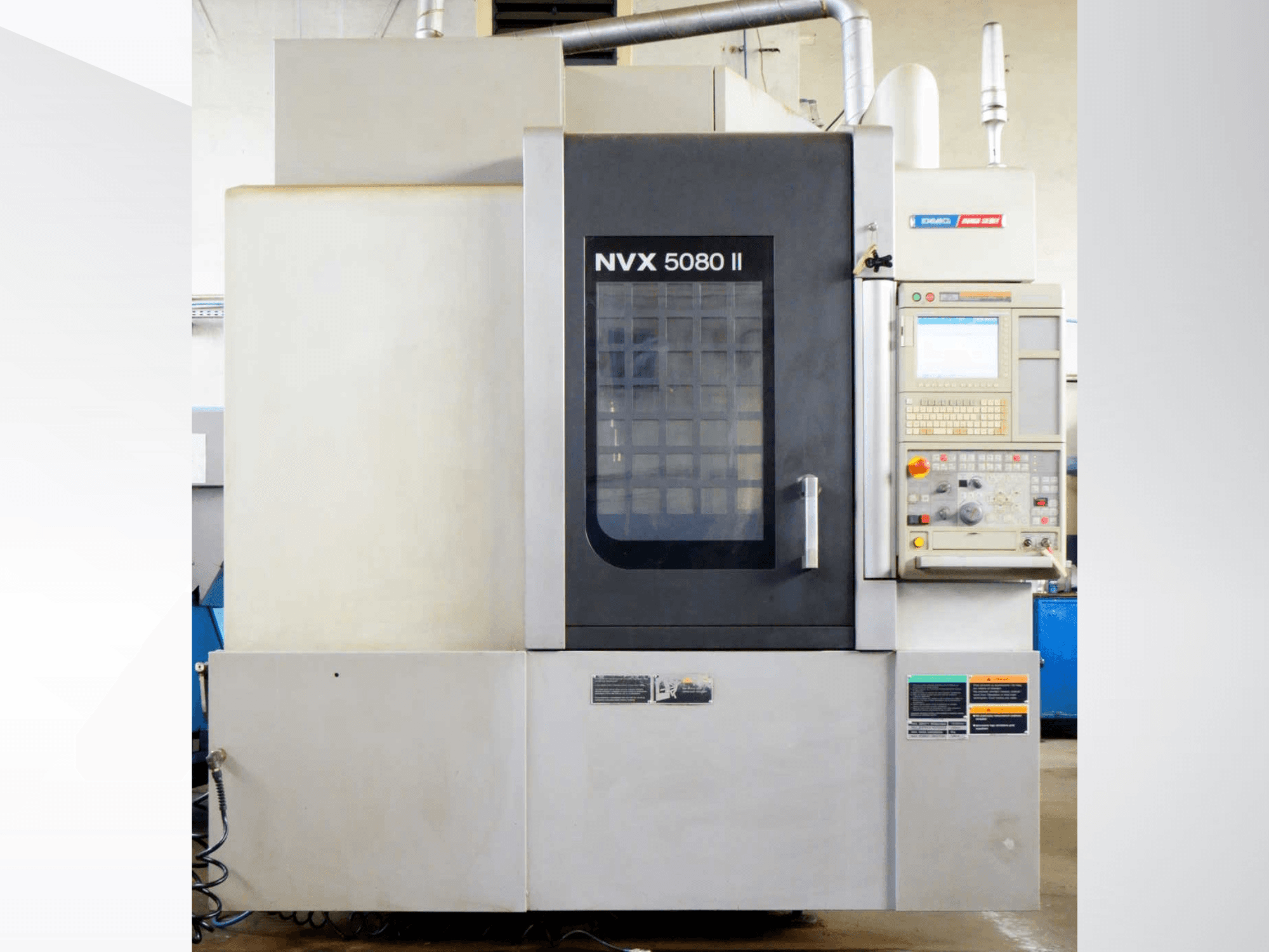 DMG Mori Seiki NVX 5080 II vertikaalne töötlemiskeskus, vaade eest, millel on juhtpaneel ja võreuksega disain.