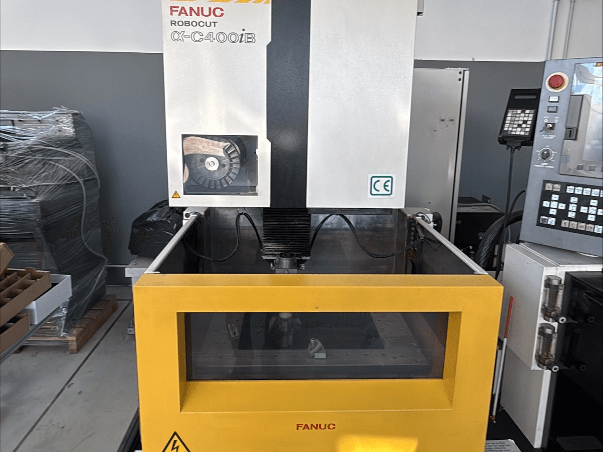 FANUC Robocut α-C400iB traadikeermismasin, esiplaanil, kollane paak ja juhtpaneel.