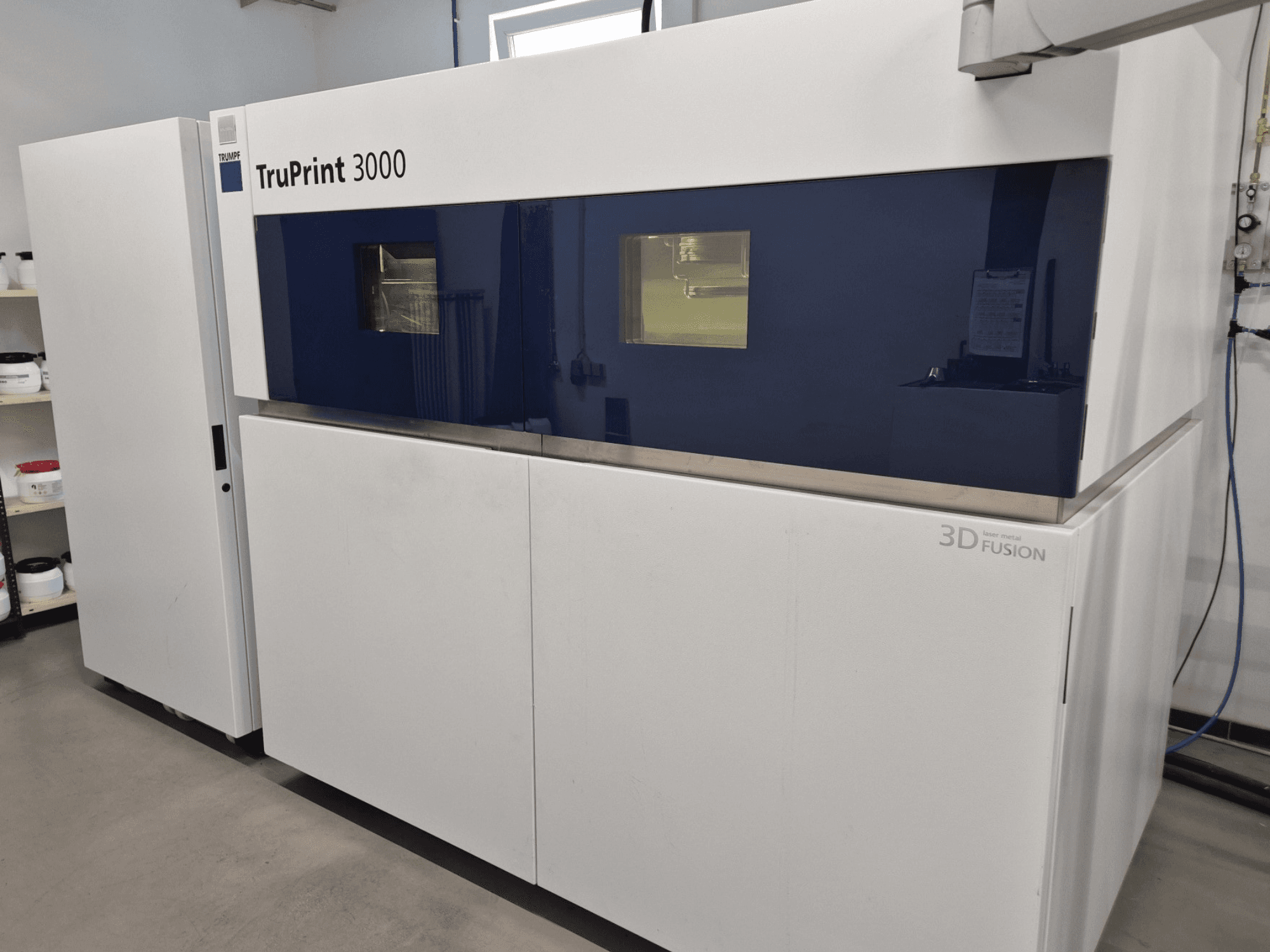 TruPrint 3000 metallist 3D-printer esiplaanil, millel on sinise paneeliga disain ja lasersulamistehnoloogia.
