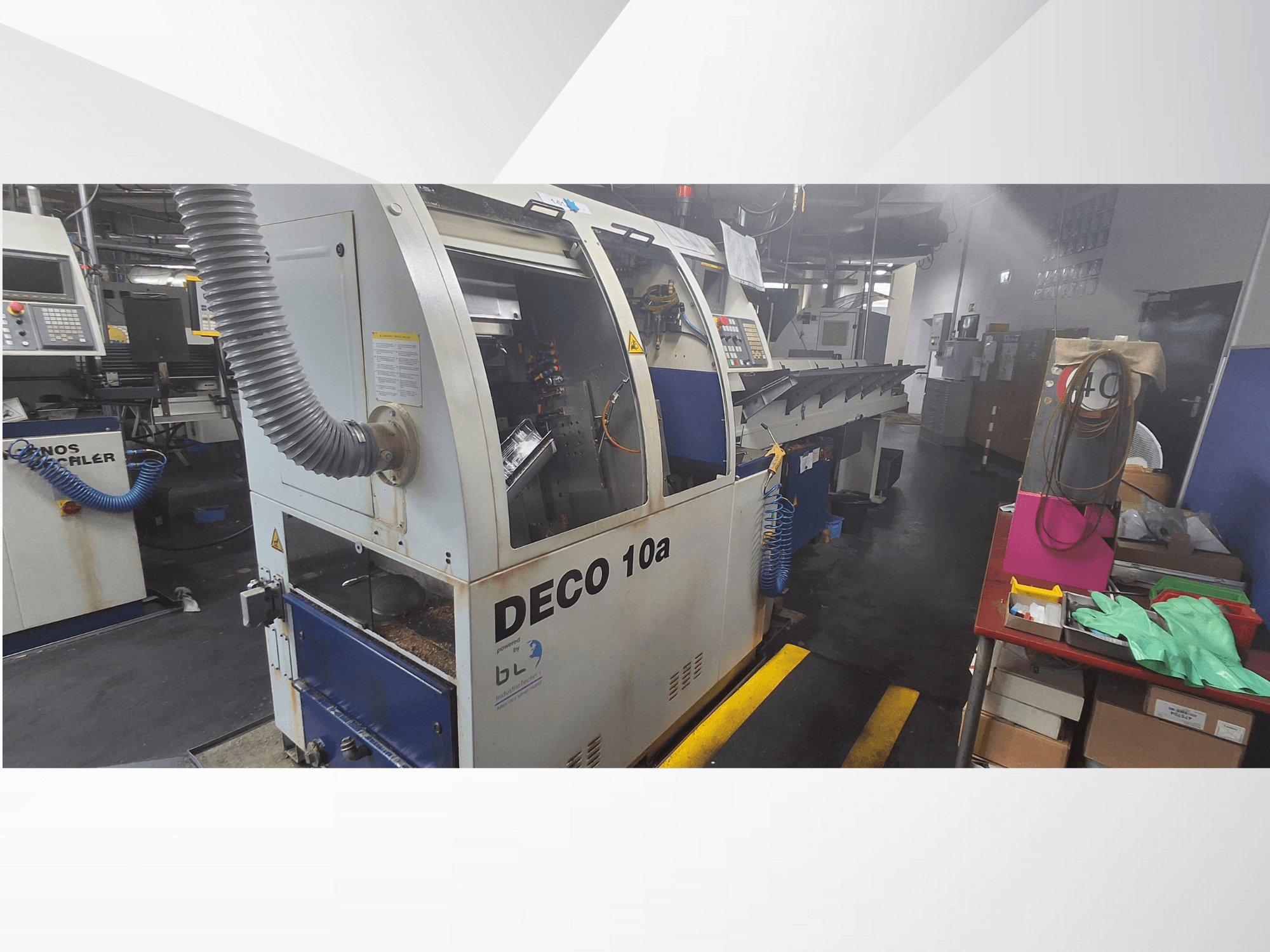 DECO 10a CNC-pink töökojas, esivaade; juhtpaneel ja tolmueemaldussüsteem, töölaud lähedal.