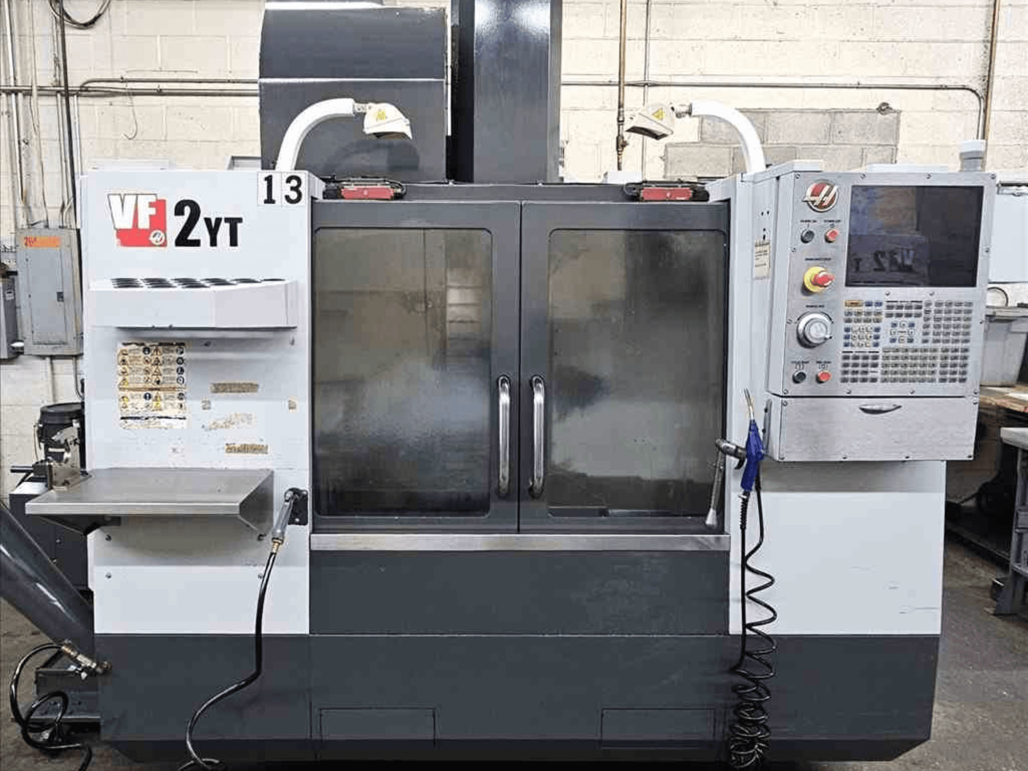 HAAS VF-2YT vertikaaltöötluskeskuse esiplaan, kus on näha juhtpaneel ja klaasuksed.