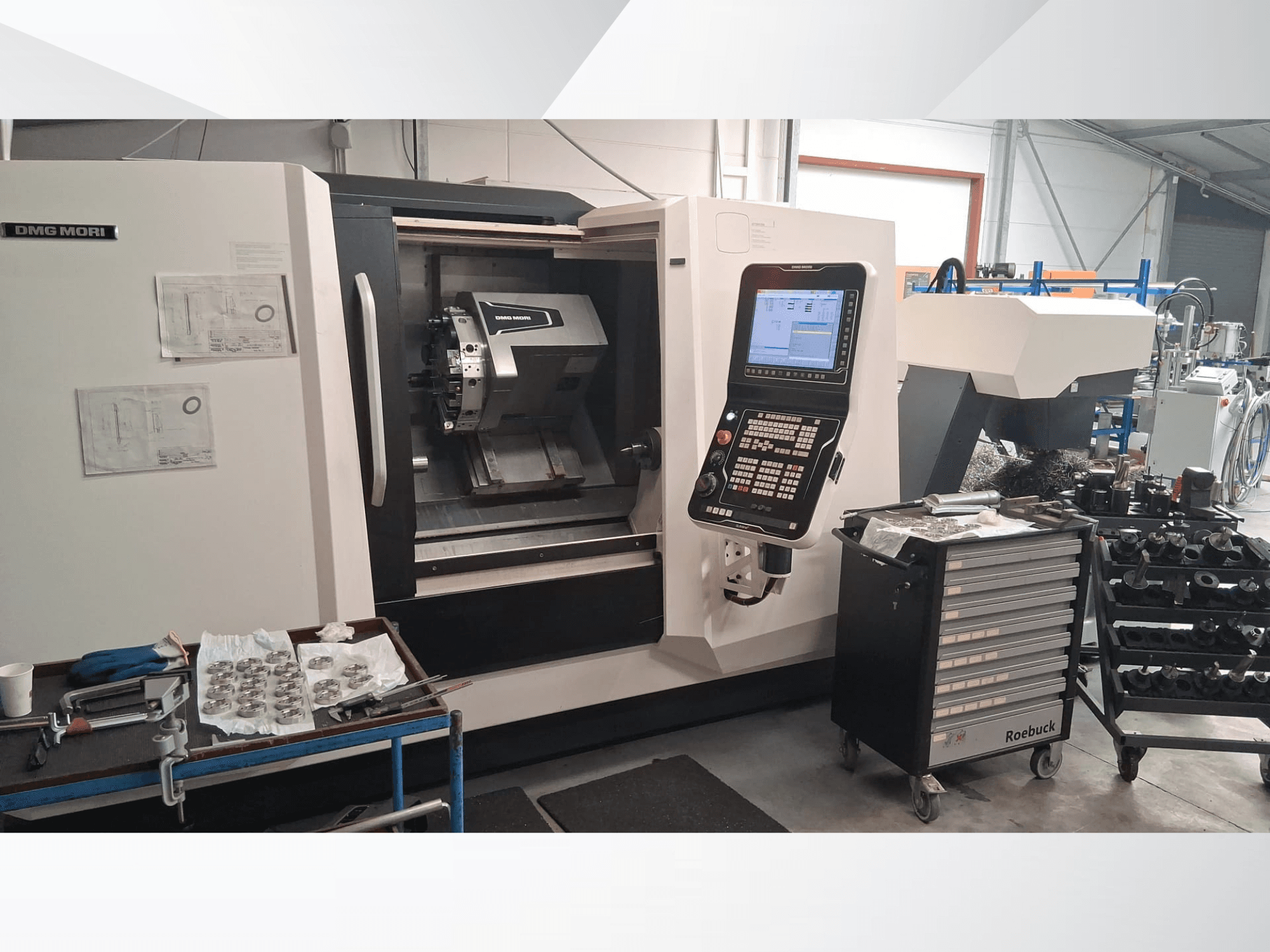 DMG MORI CLX450 horisontaalne treipink eesvaates, millel on juhtpaneel, tööala, tööriistad ja metallosad.