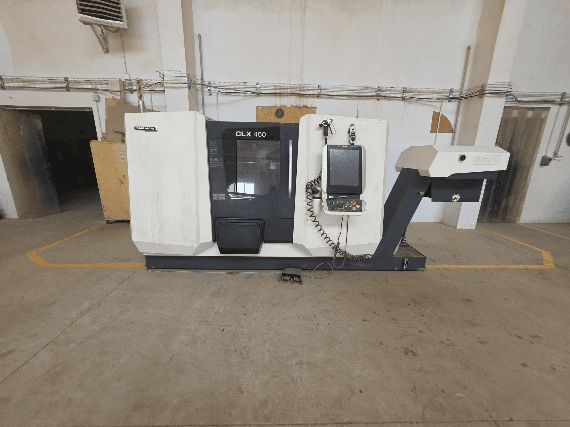 Horisontaalne vaade DMG MORI CLX 450 V4 treipingile, kus on juhtpaneel, spindli ala ja puhas tööstuslik seade.