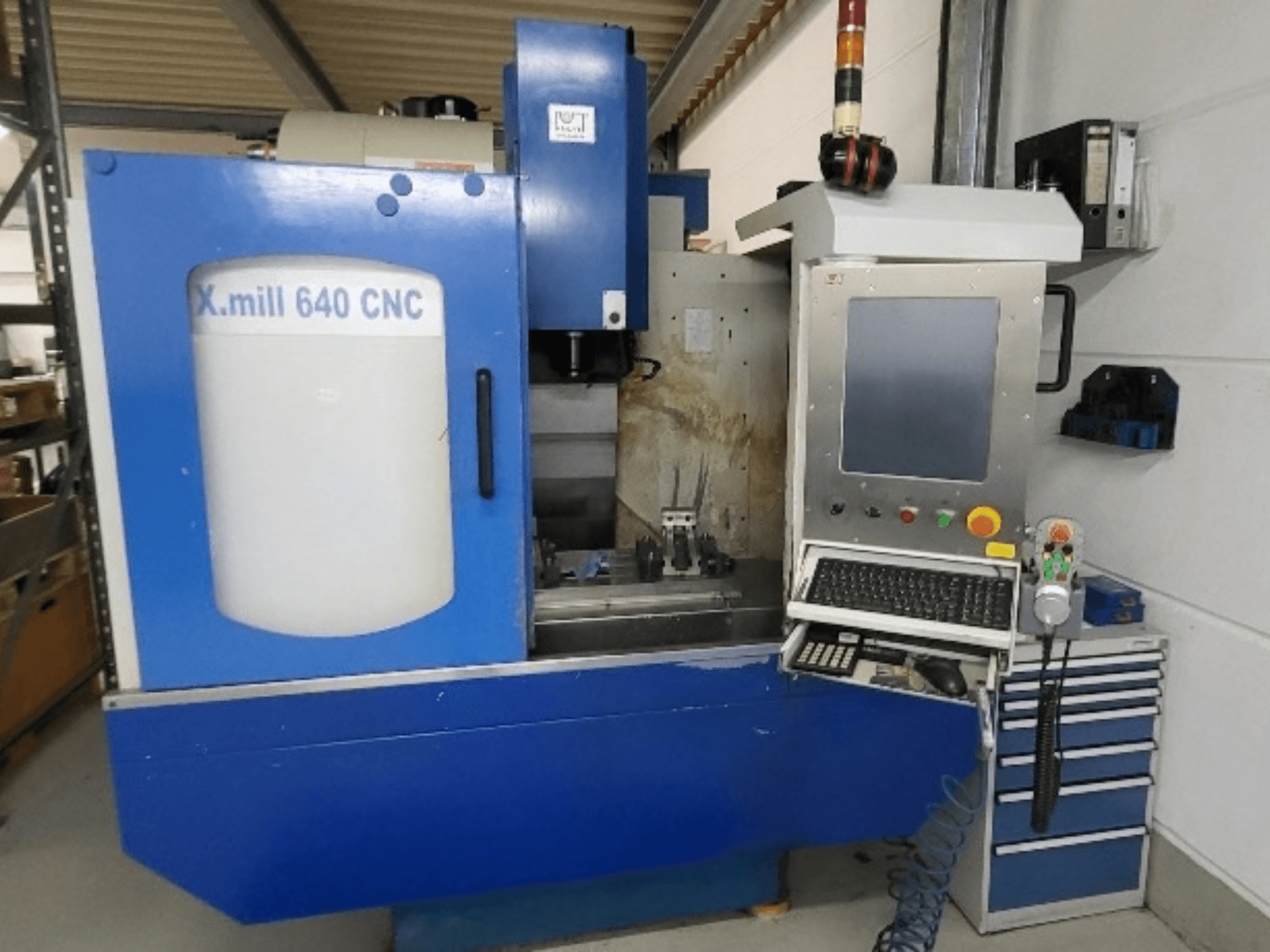Sinine KNUTH X-mill 640 CNC vertikaalne töötlemiskeskus, vaade eest, kus on näha juhtpaneel ja klaviatuur.