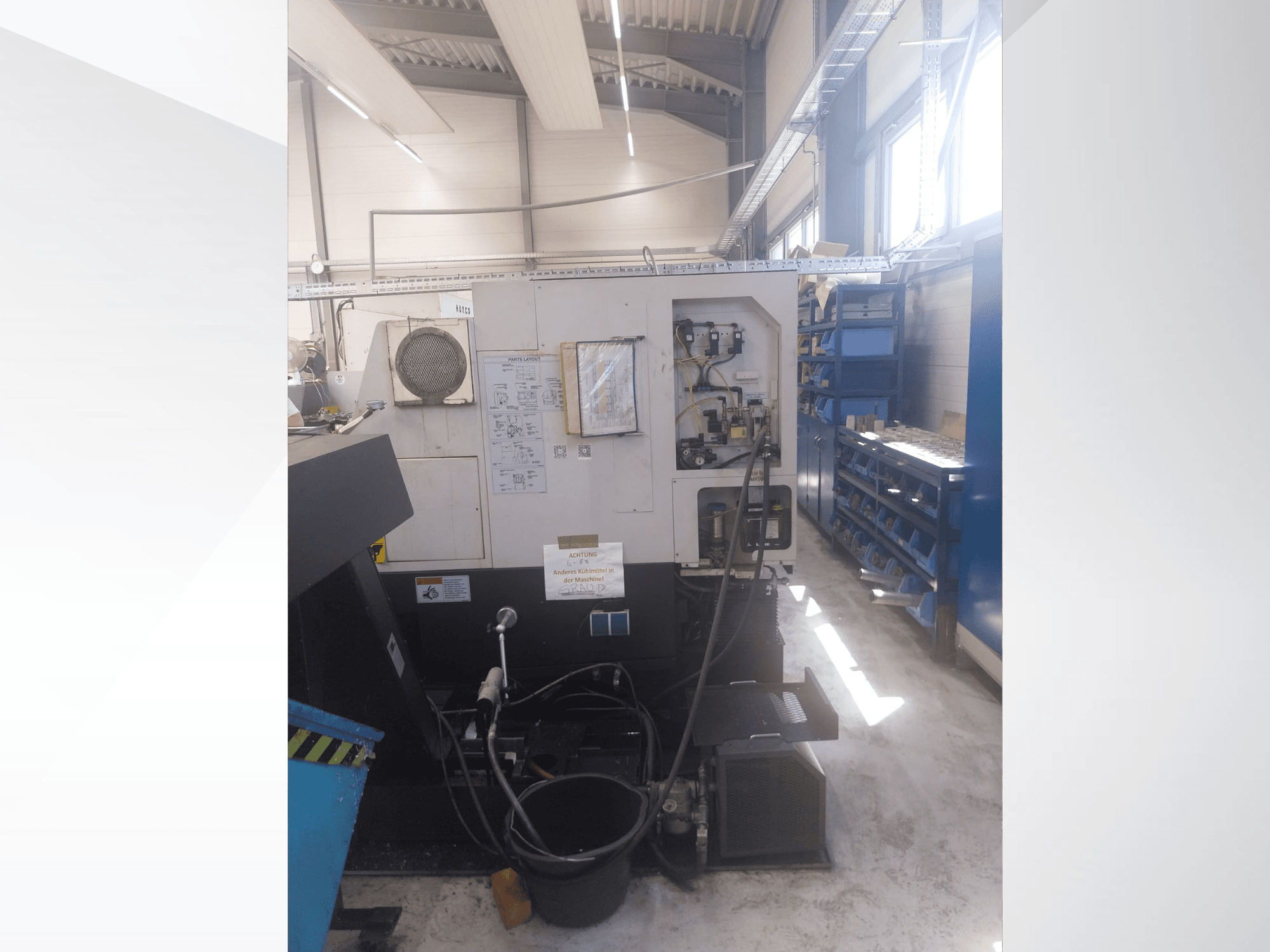 Mazak QUICK TURN NEXUS 200 MS, külgvaade, millel on näha juhtpaneel, voolikud ja tööriistade ala töökoda keskkonnas.