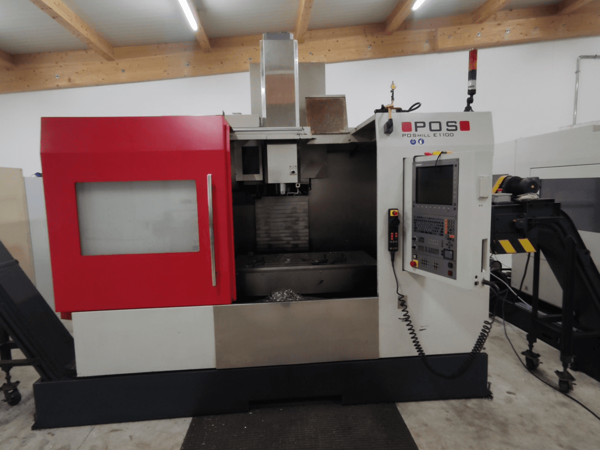 POS PSMILL E1100 CNC-freesping, esiplaanil, punase ja hõbedase korpuse, juhtpaneeli ja ohutustuledega.