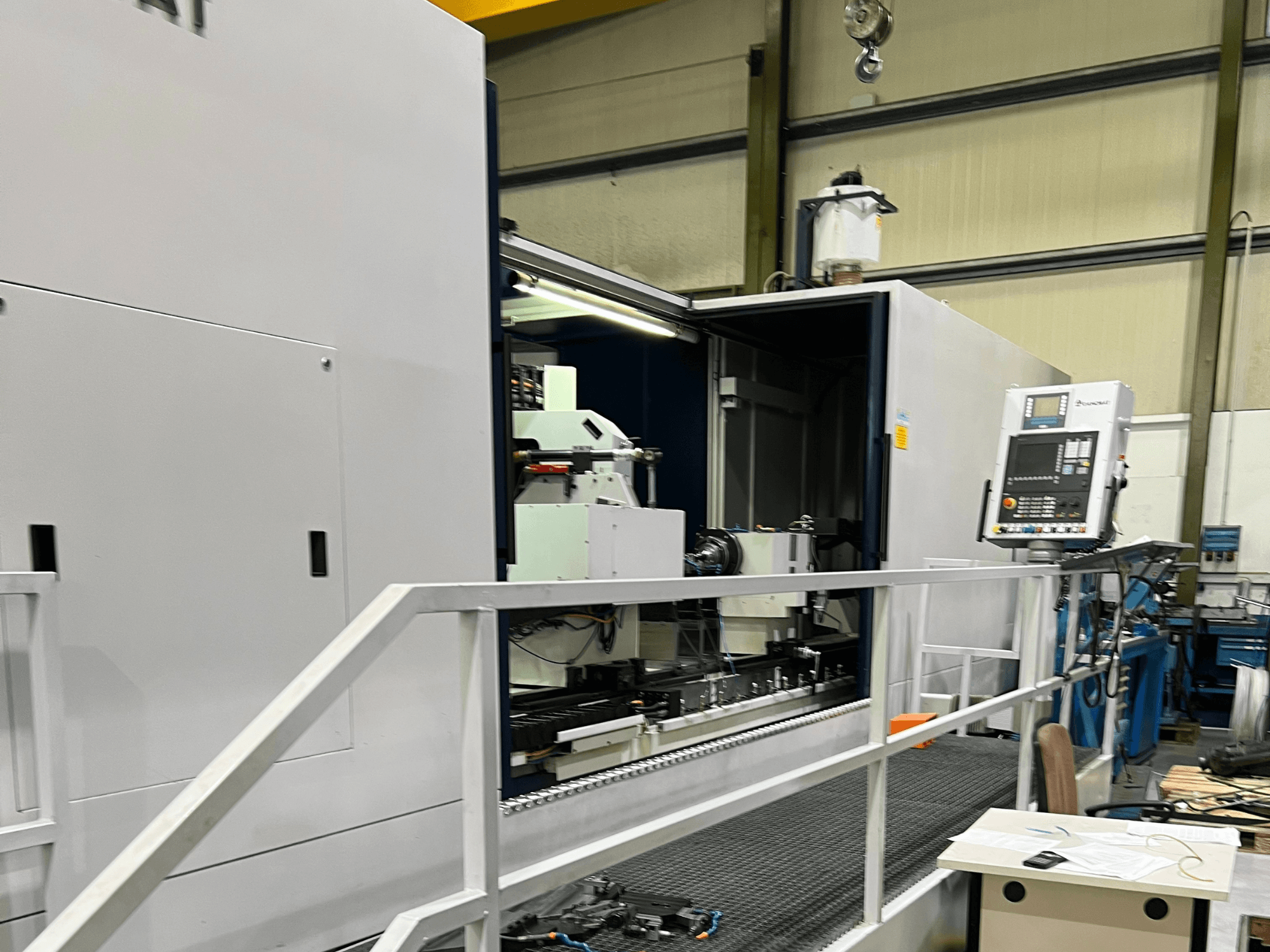 CNC-töötluskeskus avatud külgvaates, kus on näha juhtimisseadmed, tööriistahoidja ja põhikomponent sees. Marki üksikasjad ei ole nähtavad.