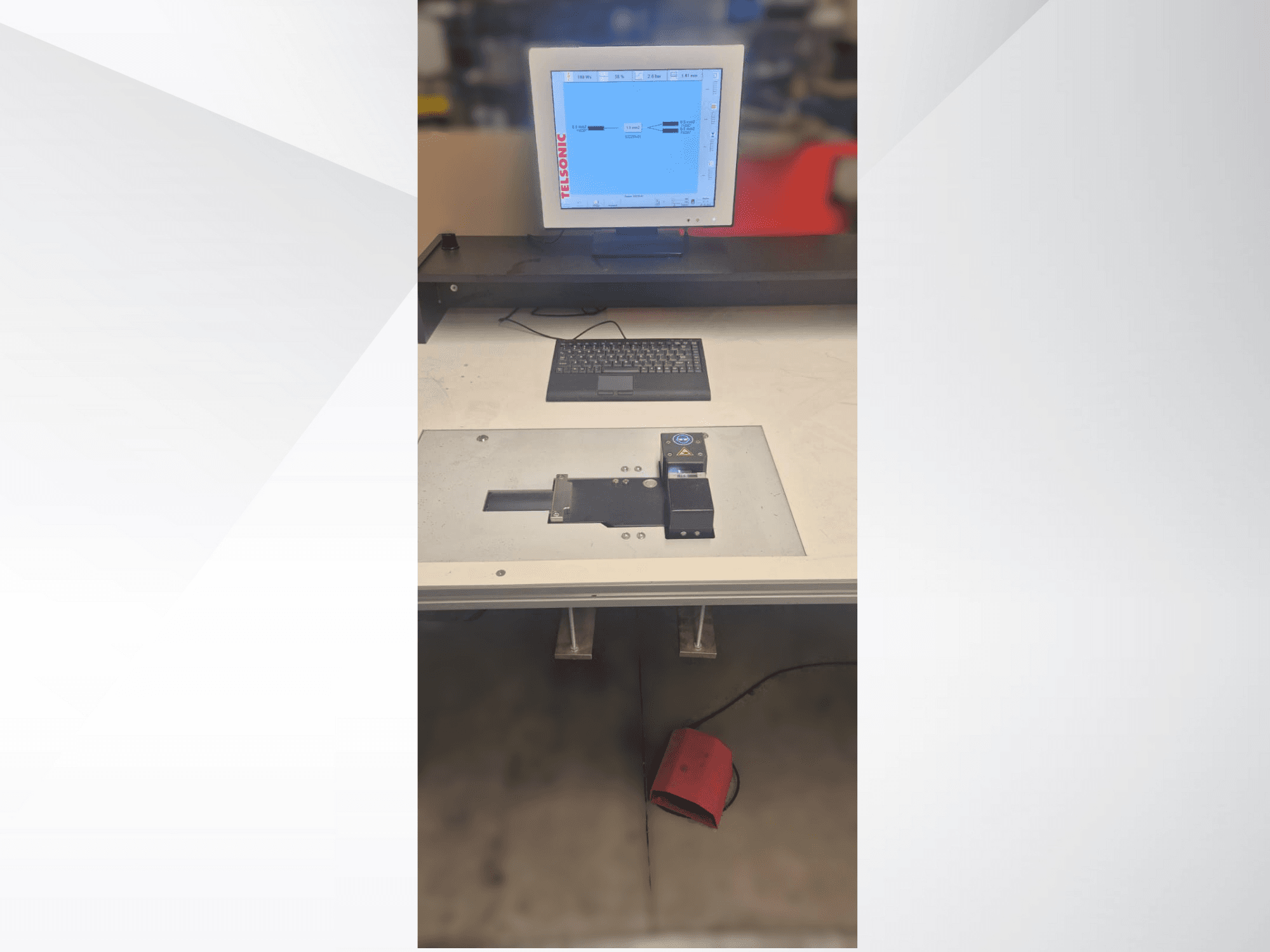 Ülevalt alla vaade testimisjaamale koos arvutimonitori, klaviatuuri ja juhtpaneeliga, millel on nupp ja roheline tuli.