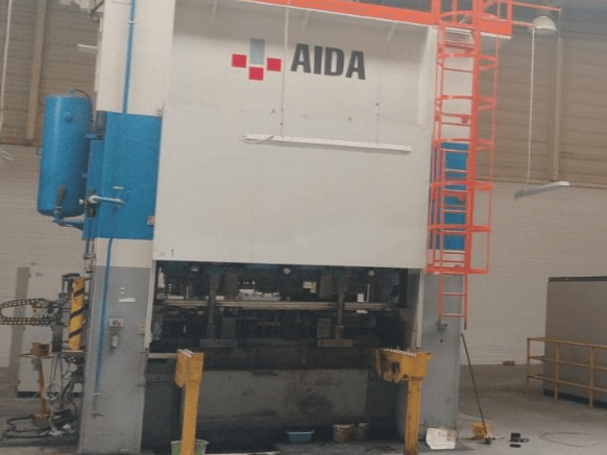AIDA mehaaniline stantsimispress 315/2MR/LD/TE3, esiplaanil, hüdraulilised komponendid ja ohutusredel.