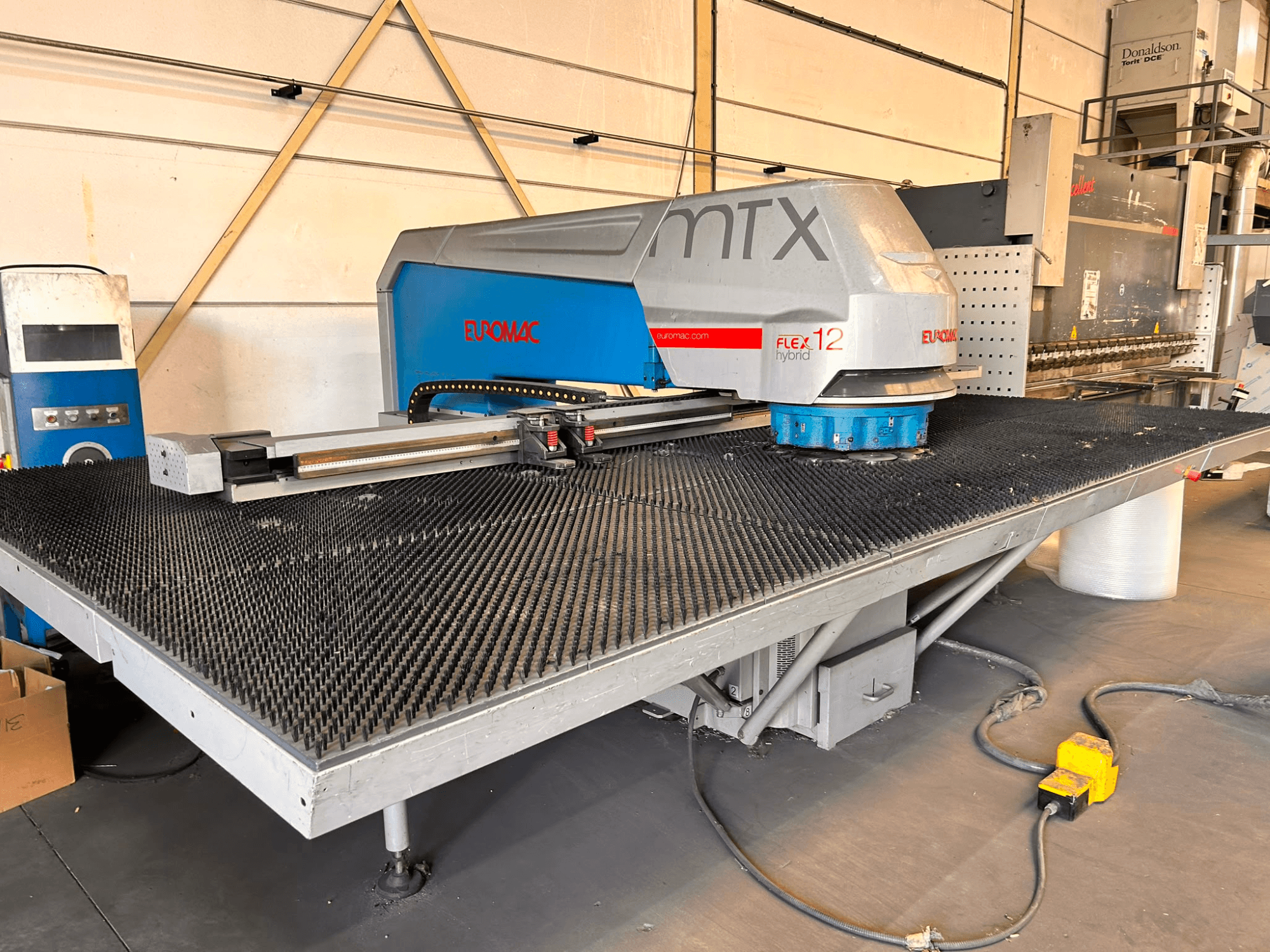 Euromac MTX FLEX 12 CNC-perforeerimismasin, vaade eest, millel on suur perforeeritud laud ja juhtpaneel.