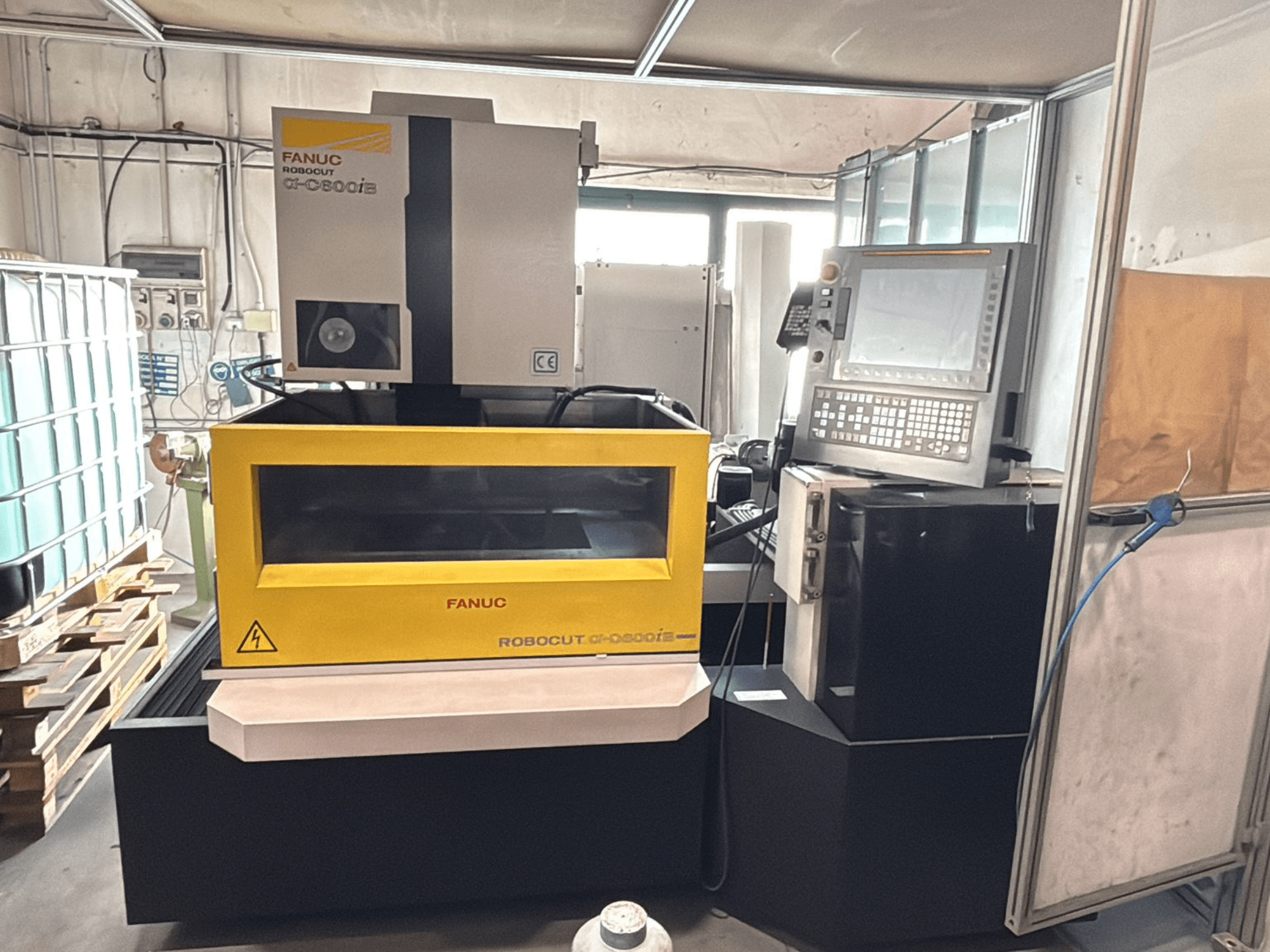 FANUC Robocut α-0iE CNC-tööpinkide esiosa kollase korpusega, kus on näha juhtpaneel ja ekraan.