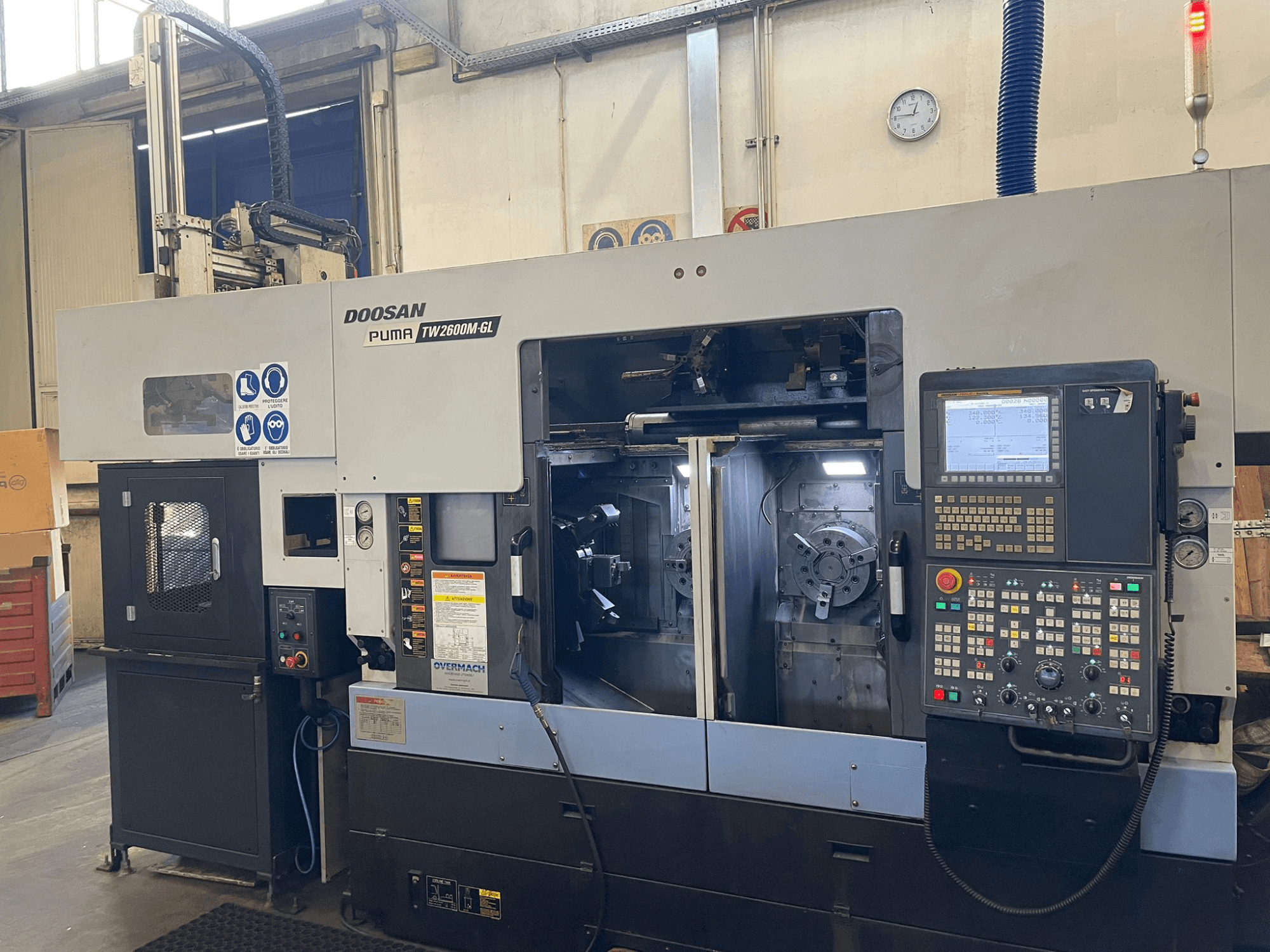 Doosan Puma TW2600M GL CNC-teeninduspingi esivaade, millel on digitaalne juhtpaneel ja masina sisemus koos tööriistahoidikutega.