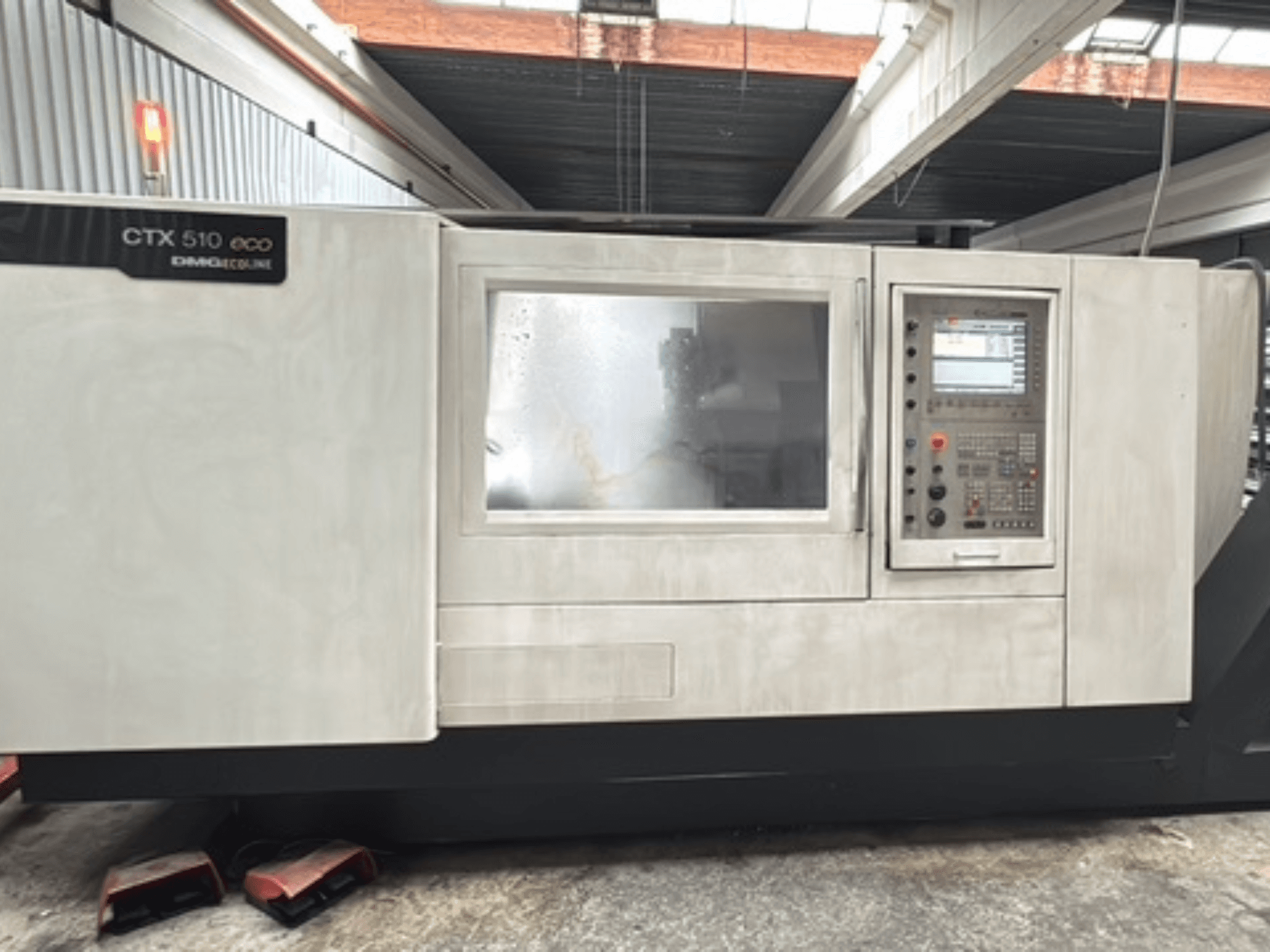 Horisontaalne treipink DMG CTX 510 ecoline, vaade eest, millel on näha juhtpaneel ja aken masina korpusel.
