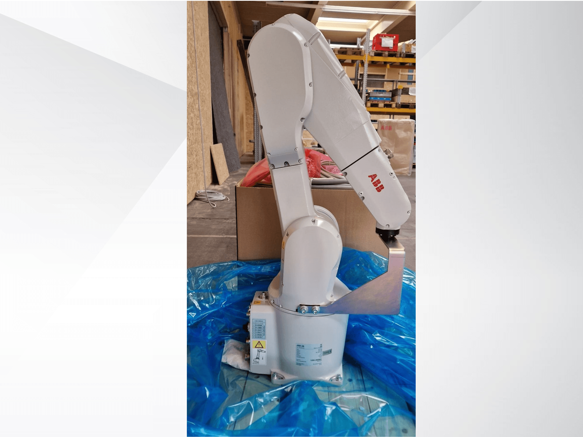 ABB robotkäe mudel, külgvaade sinisel tarrendil, näidates liigendliigeseid ja metallist otsaefektorit, nähtavad tehnilised sildid.