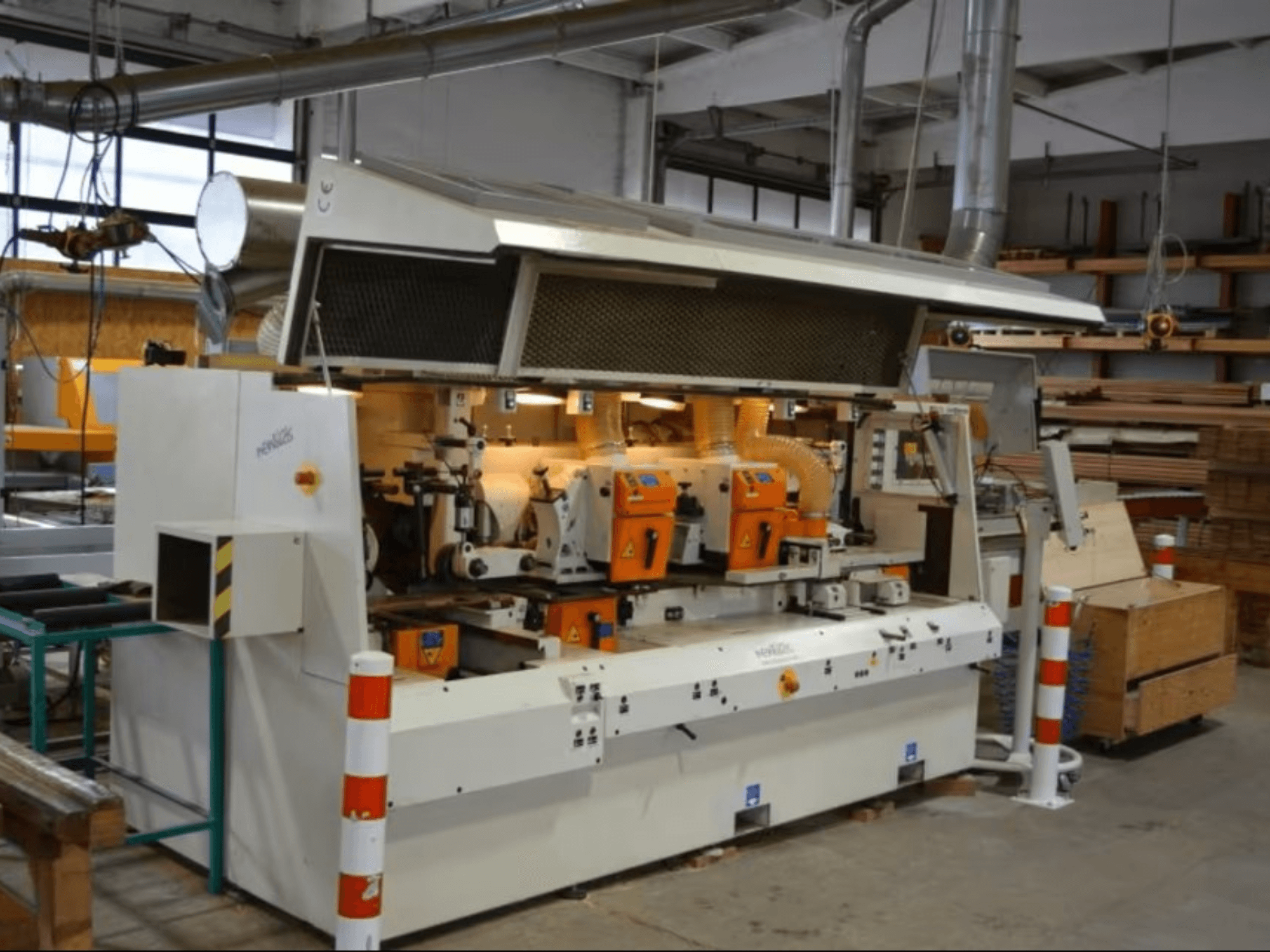 PENIGAS puidutöötlemismasin, esivaade, millel on kaks oranži lõikepinda ja tolmueemaldussüsteem töökojas.