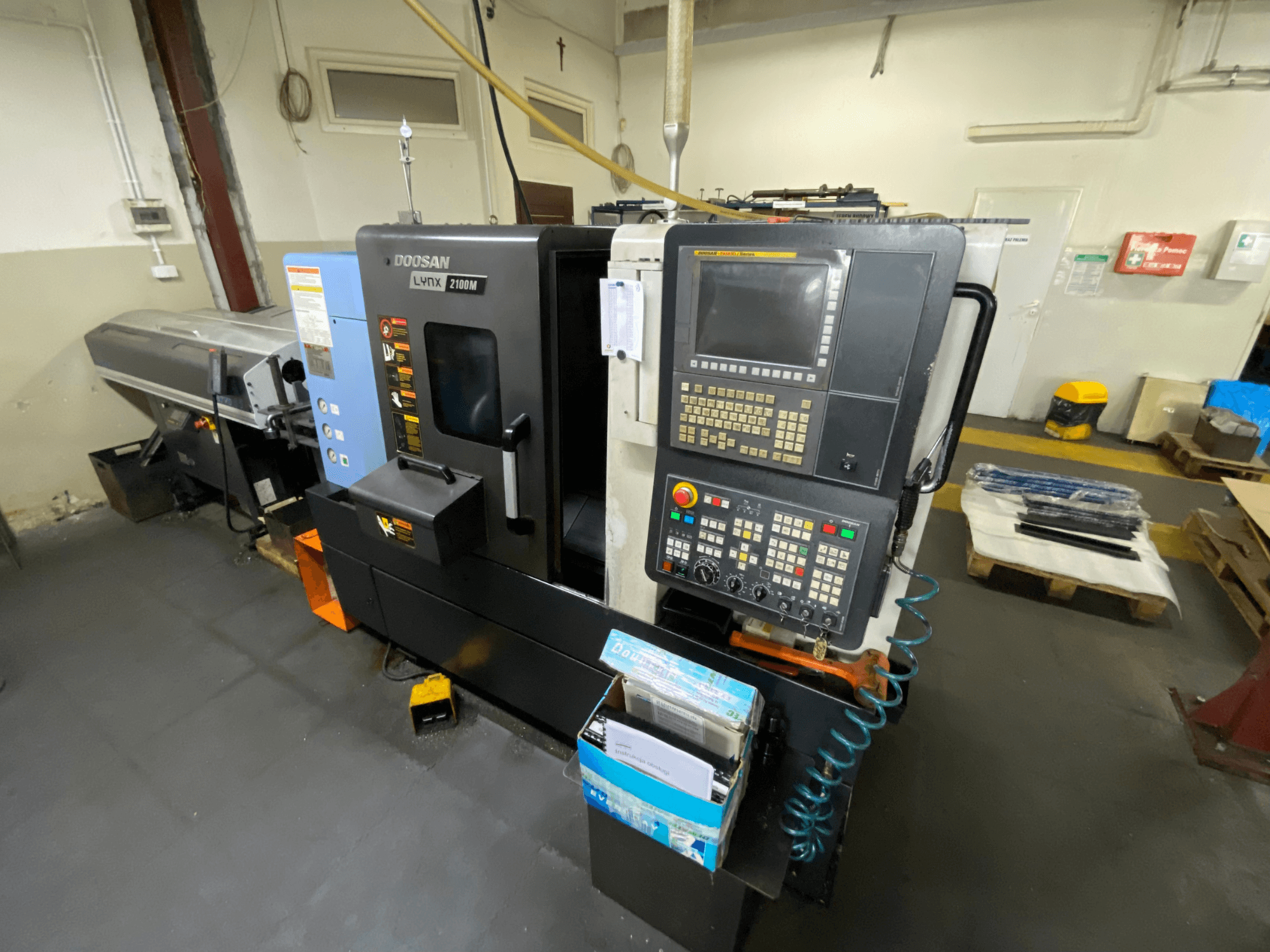 DOOSAN LYNX 2100MA horisontaalne treipink külgvaates, millel on näha juhtpaneel, tööriistad ja töötsoon.