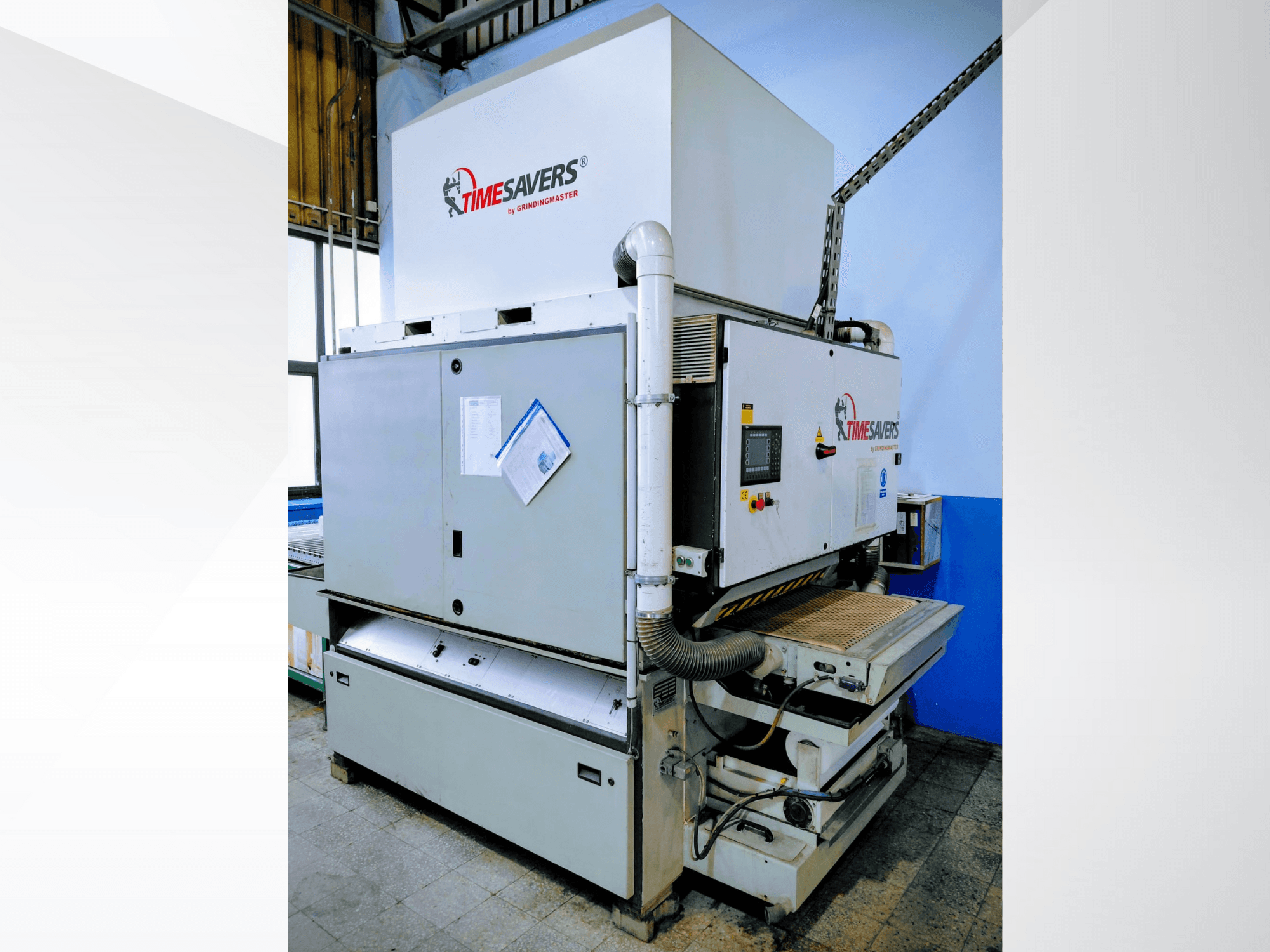 Timesaversi tööstuslik lihvija, esiplaanil. Omadused: juhtimisseadmed, tolmueemaldus ja reguleeritav lihvimisalus täpsuse tagamiseks.