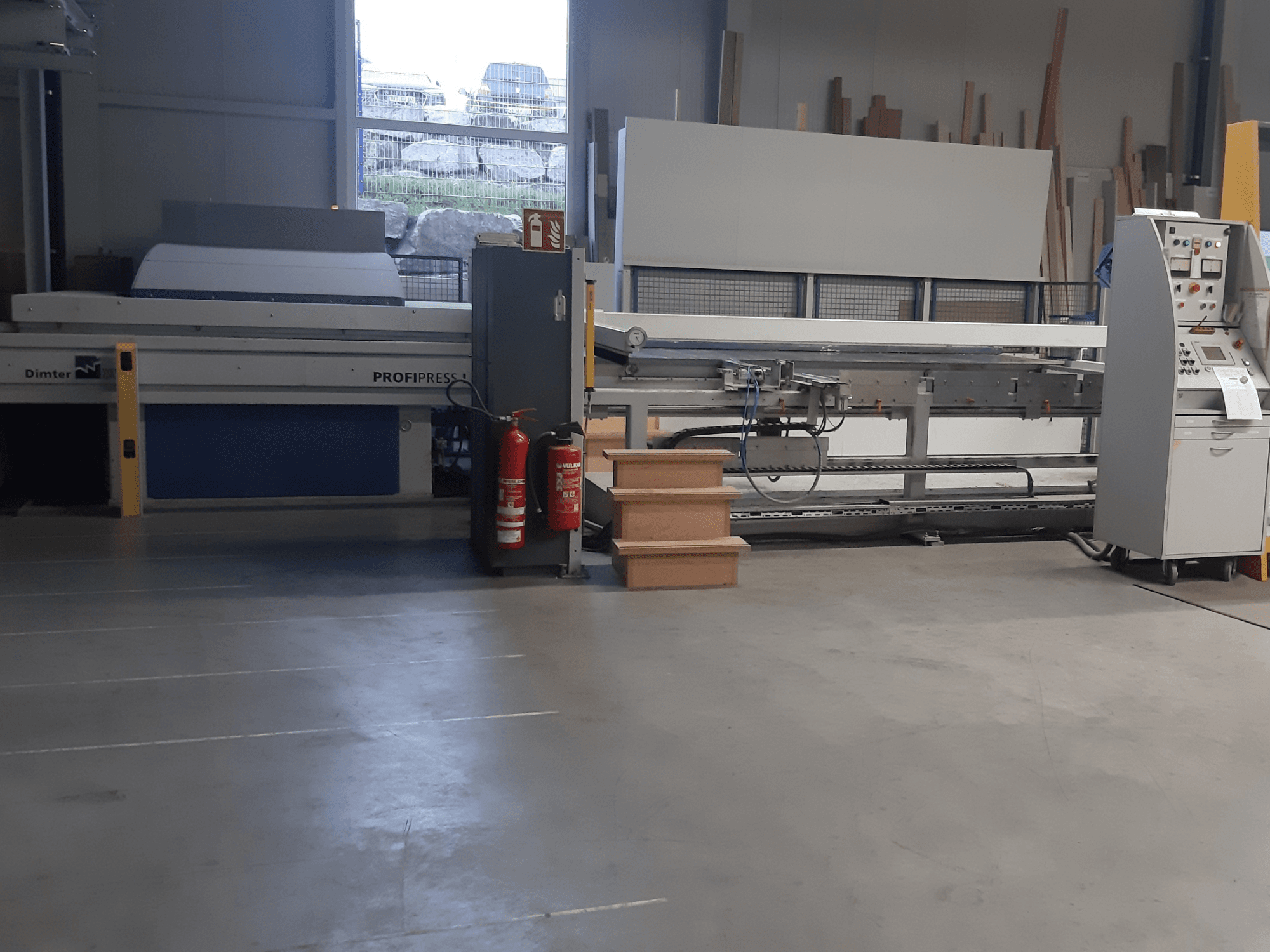 Dimter ProfiPress masin töökojas, vaadatuna eestpoolt, juhtpaneel ja tulekustutid lähedal.