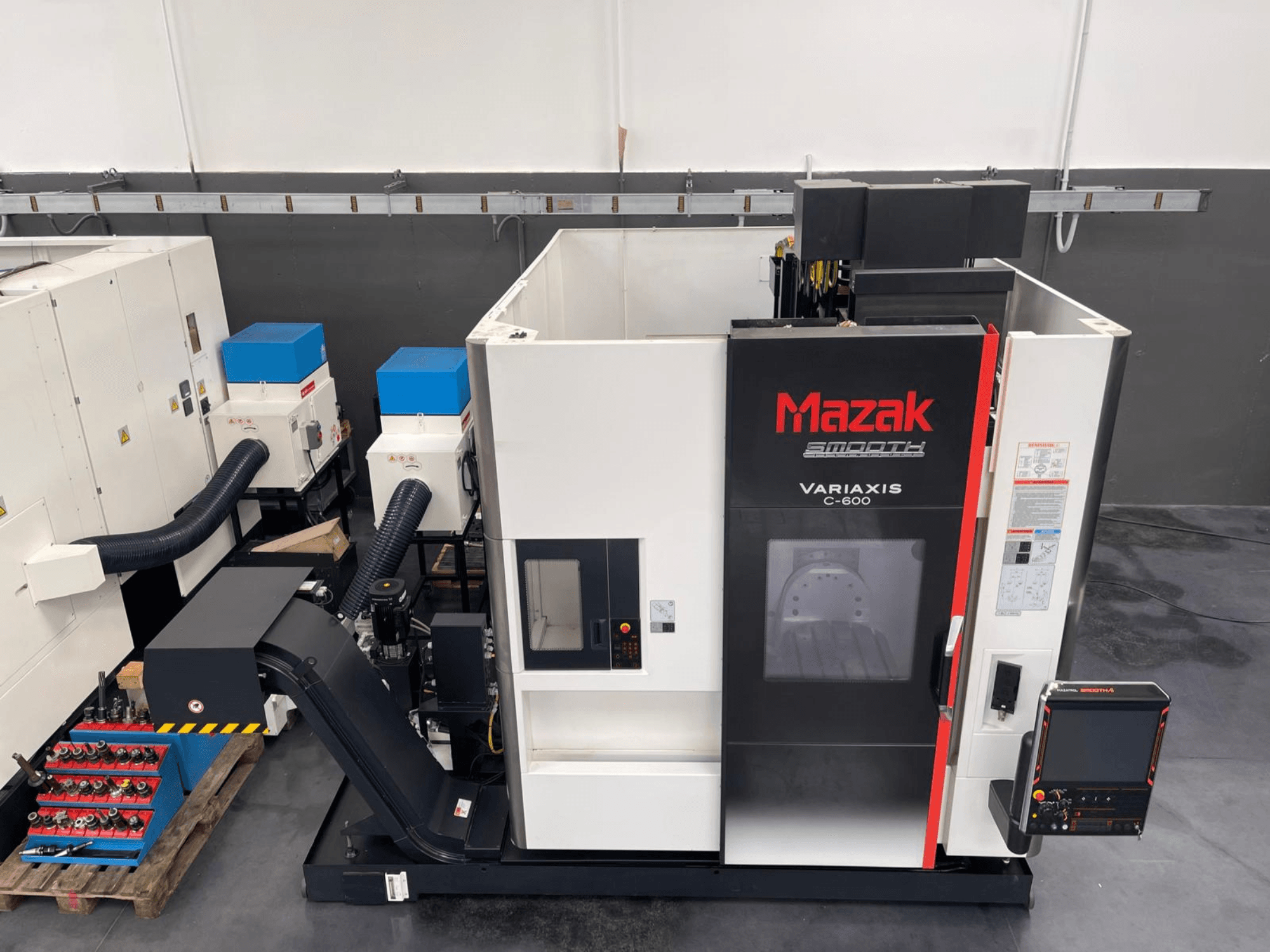 Mazak VARIAXIS C 600 vertikaalne töötluskeskus, esiplaanil on juhtpaneel ja tööriistade hoidla.