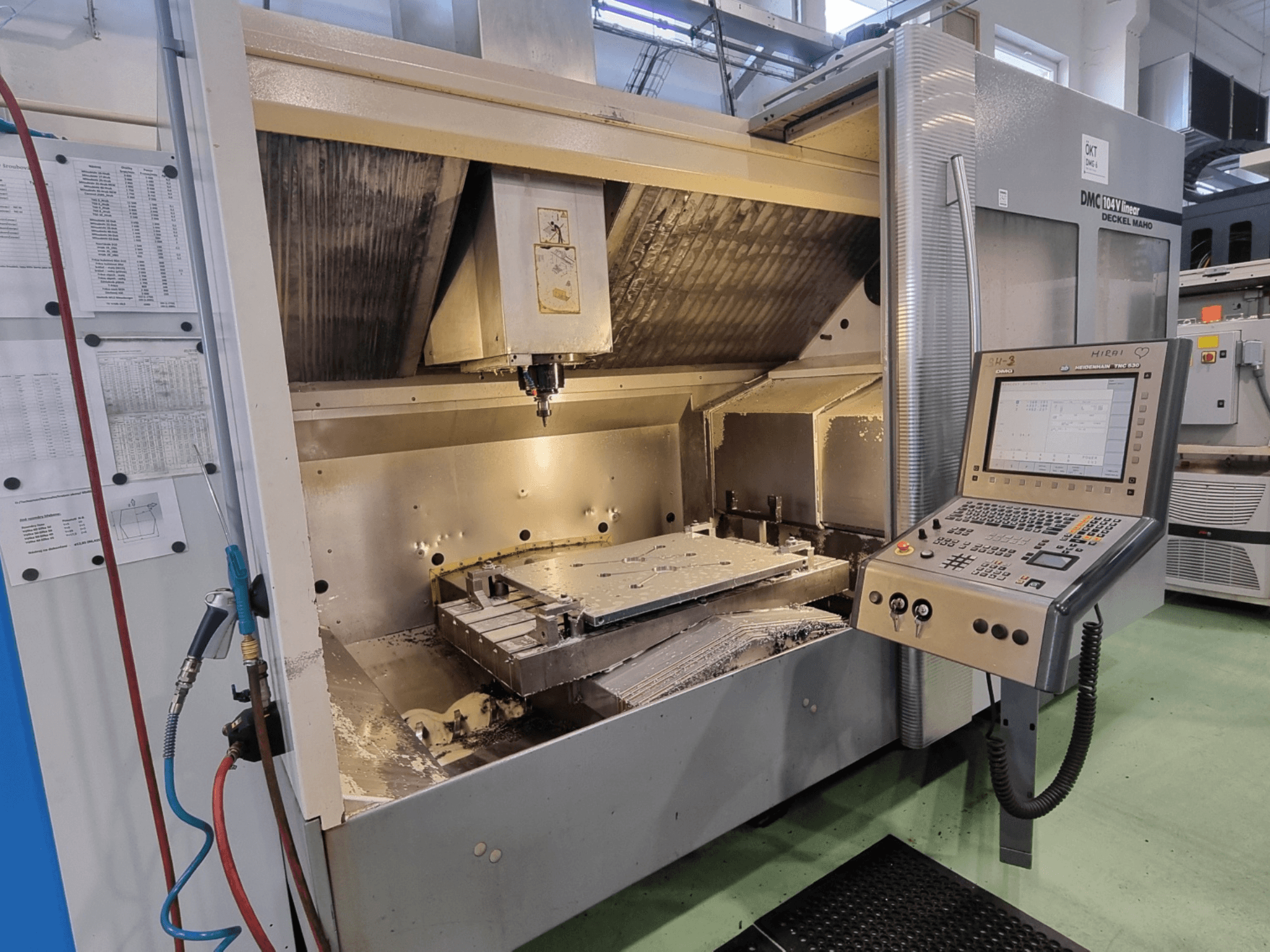 DMG DECKEL MAHO DMC 104V lineaarne vertikaalne töötlemiskeskus, vaade eest, millel on näha juhtpaneel ja töötlemisala.