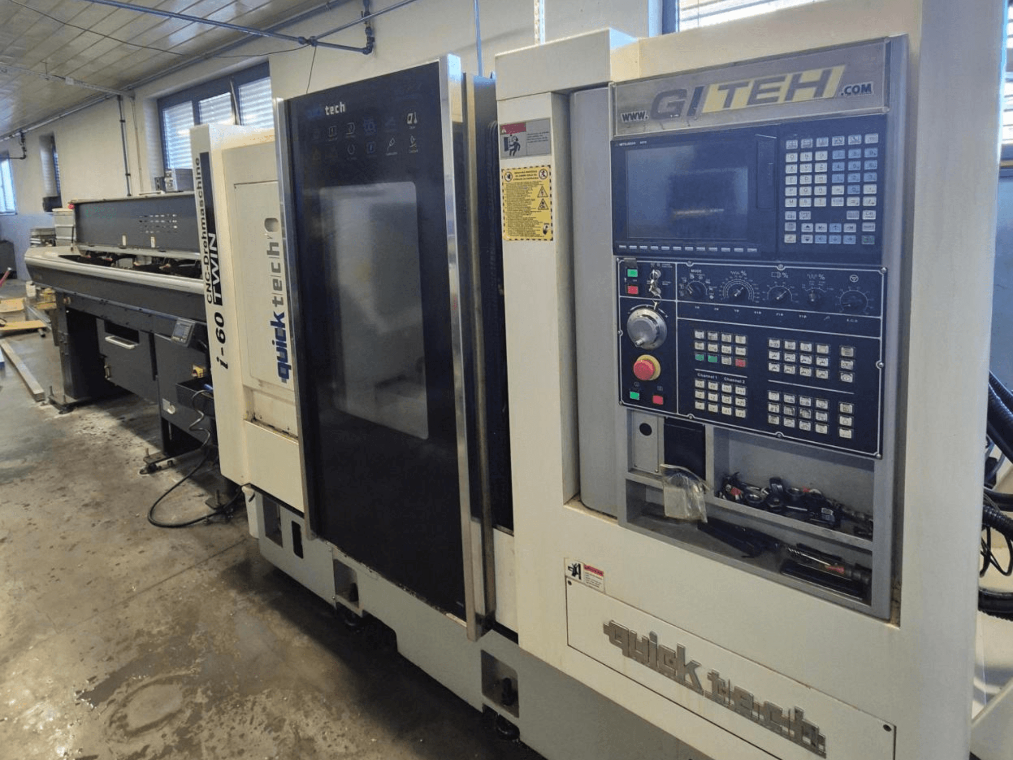 Quick Tech i-60 kaksik CNC-tööpink, esivaade, millel on GITEHi juhtpaneel ja juhtimisnupud, töökojas.