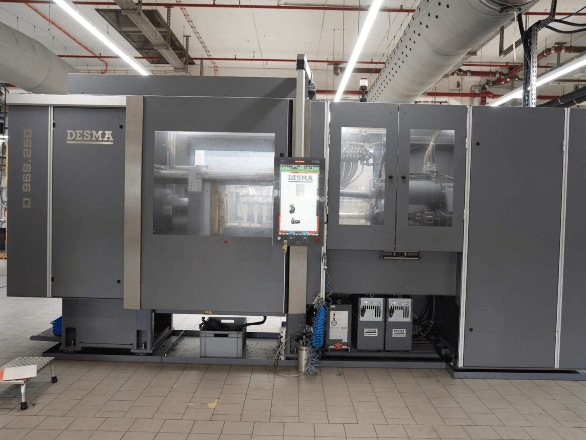 Kloeckner Desma D 969.250 Z (S3) vertikaalne survevalumasin tehase keskkonnas, vaade eest koos juhtpaneeliga.