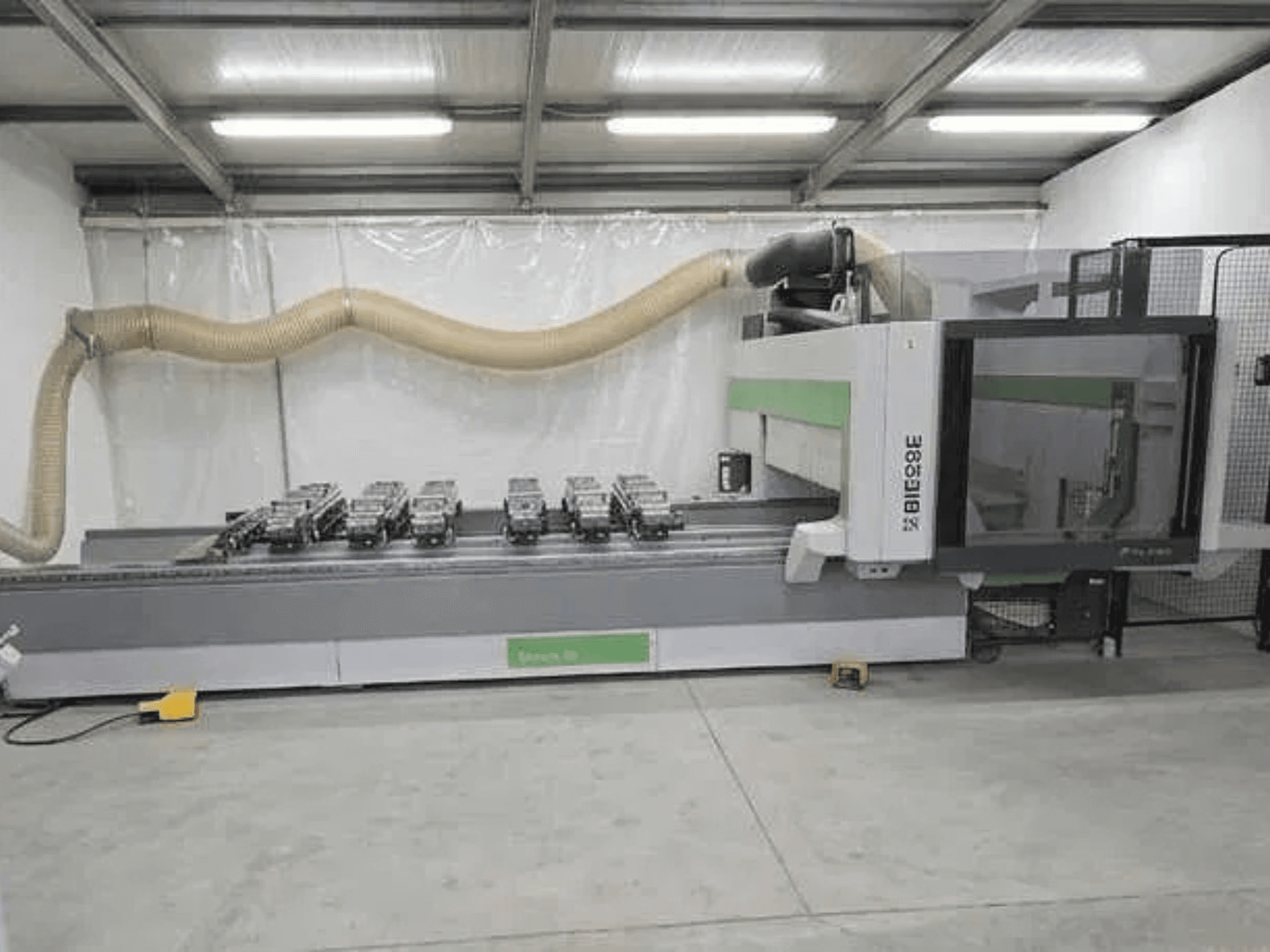 BIESSE Rover K1232 CNC-töötlemiskeskus külgvaates, millel on näha vaakumimagnetid ja tolmuärastussüsteem.