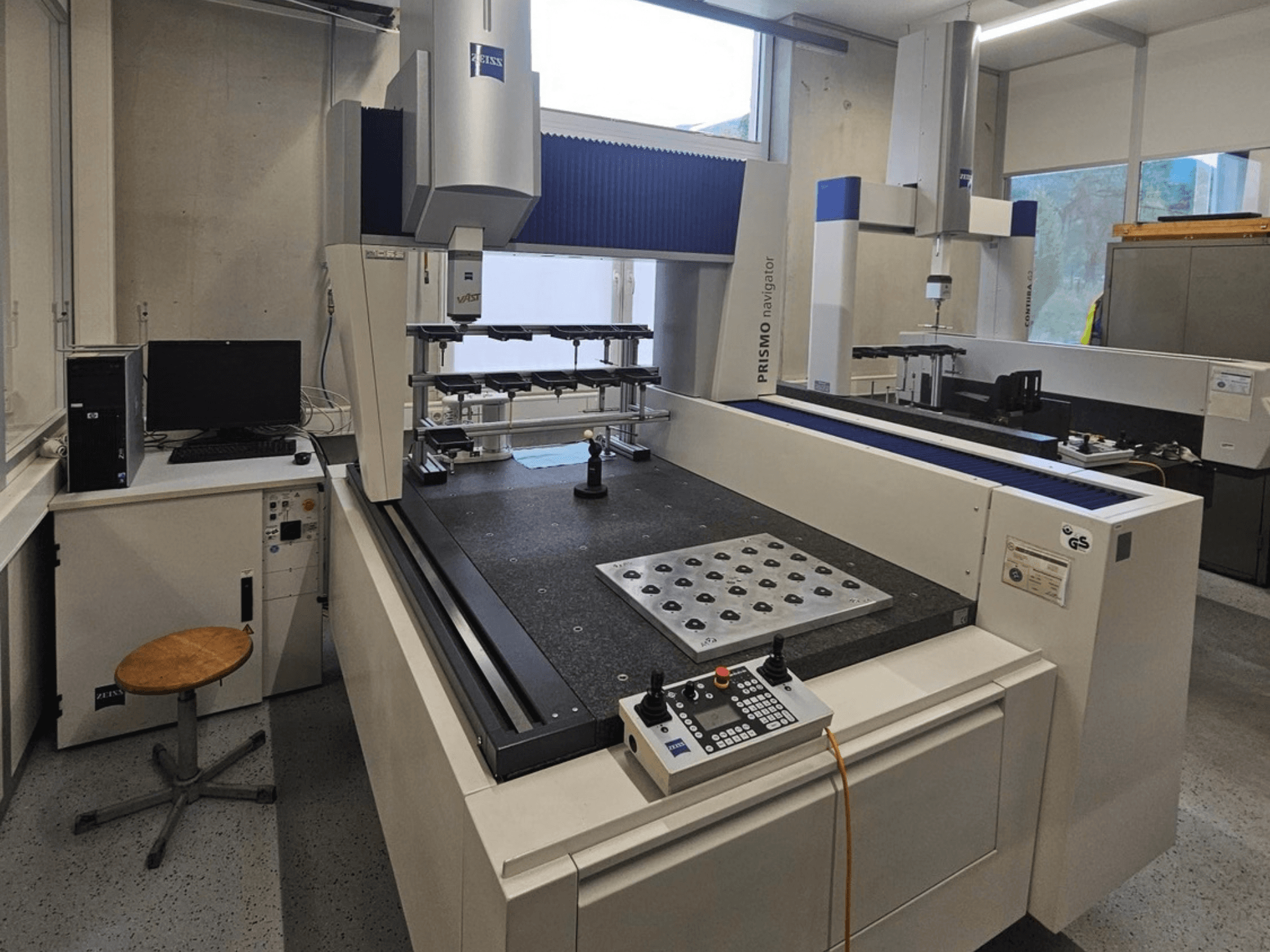 ZEISS Prismo Navigator 7 CMM laboris, esivaade, millel on näha juhtpaneel, tööpink ja monitor.