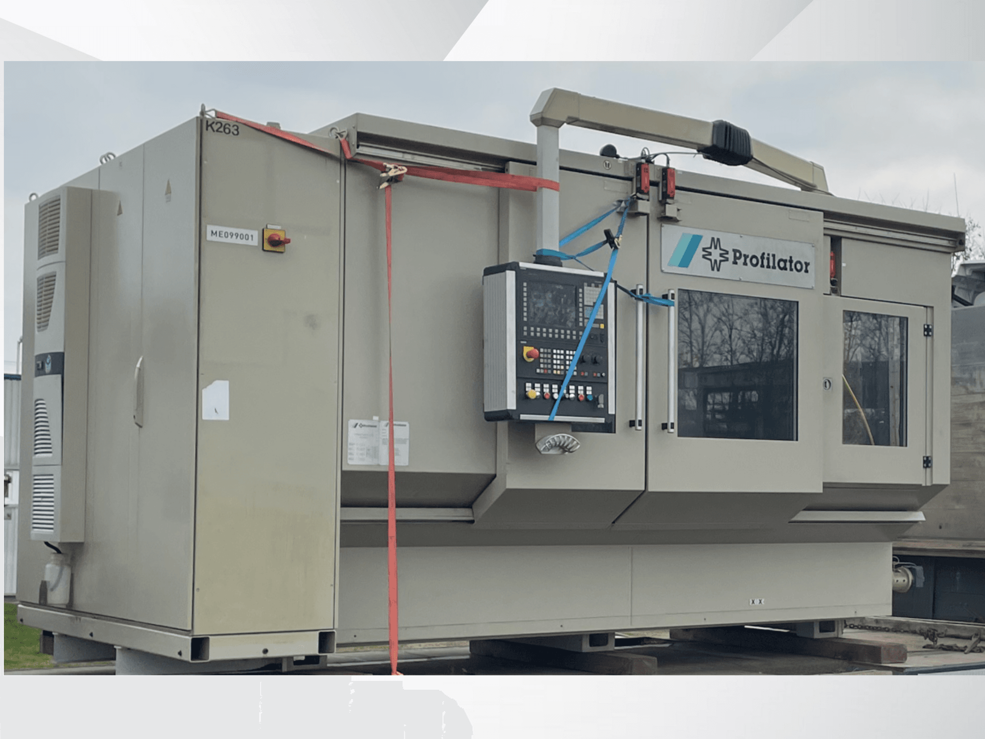 Profillatsioonimasin külgvaates, millel on juhtpaneel, ohutussildid ja kaitsevöö, puidust platvormil.