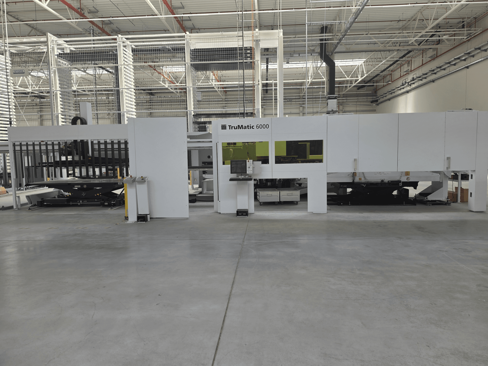 TRUMPF TruMatic 6000 automatiseeritud lehtmetalli tootmissüsteem, vaade eest, millel on näha juhtpaneel ja laadimisala.