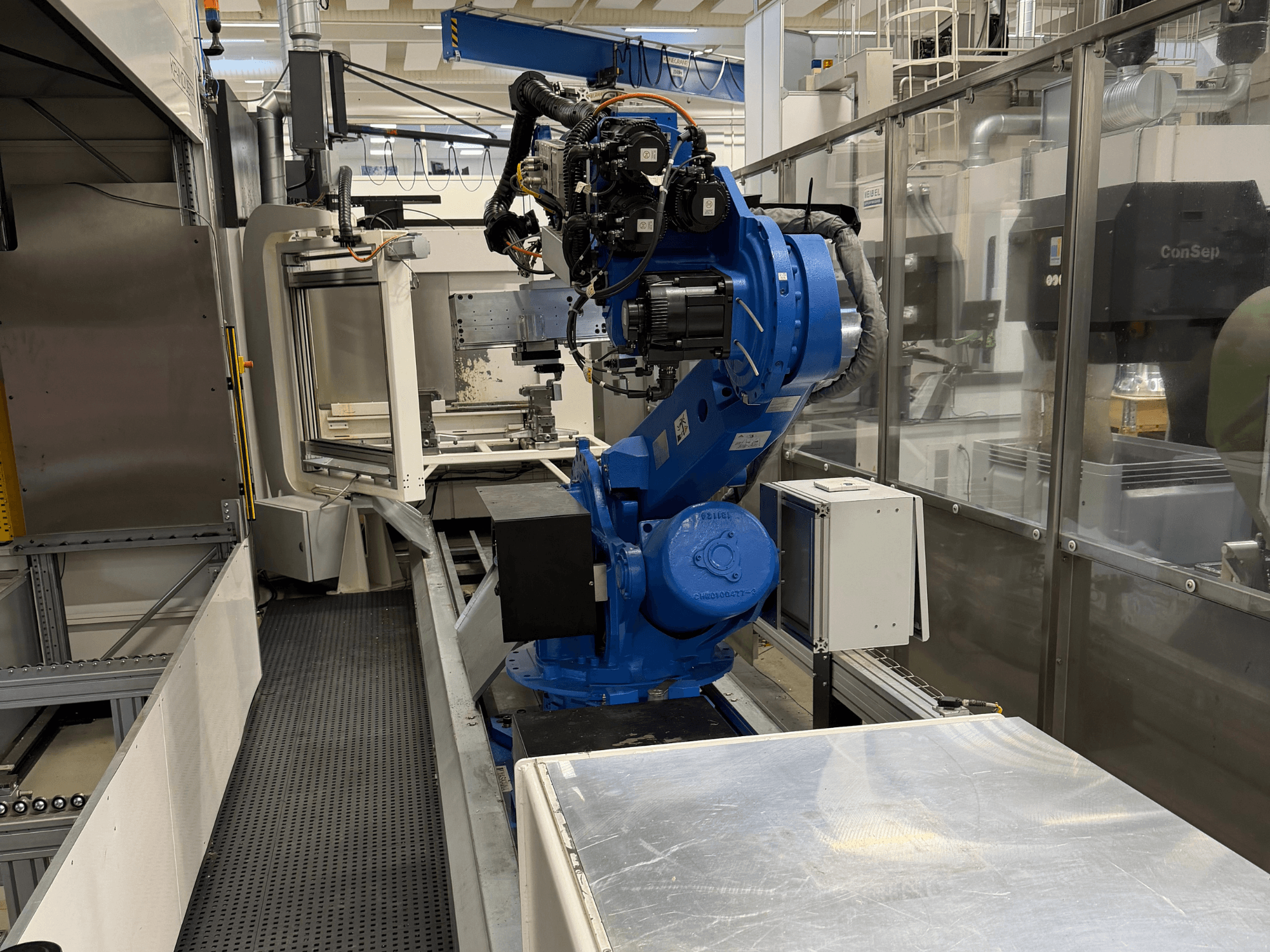 Yaskawa Motoman ES165D robotkäsi rööbastel, külgvaade näitab automaatika seadistust tööstuskeskkonnas.