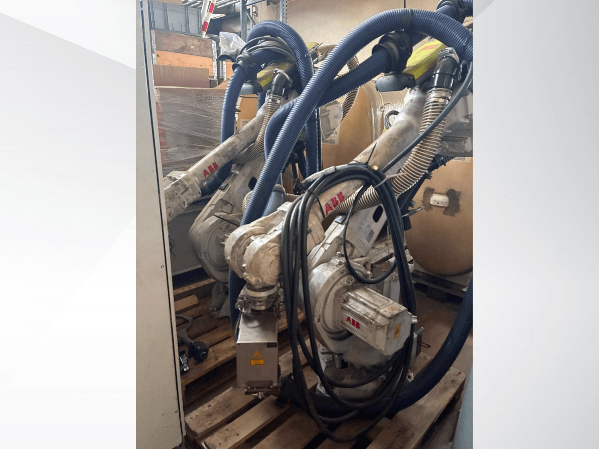 ABB IRB 4600-40/2.55 robotkäsi, külgvaade, millel on näha kaks kätt ja nendega ühendatud voolikud; paigaldatud kaubaalustele laos.