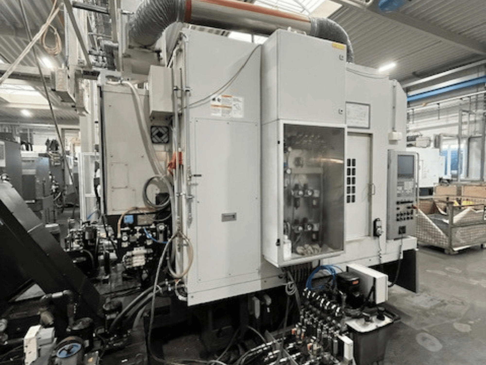 Tööstusmasina külgvaade, millel on juhtpaneel ja hüdraulikakomponendid, mis näitab kaubamärgi ja mudeli üksikasju.