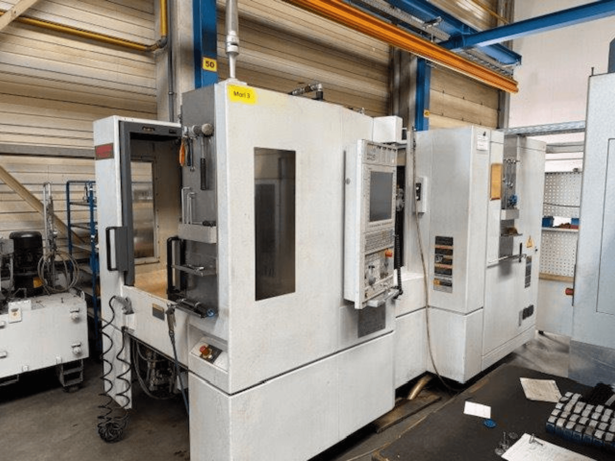 MORI SEIKI NH4000 DCG horisontaaltöötluskeskuse esiplaan, avatud uks ja juhtpaneel nähtavad, mis näitab tööruumi.